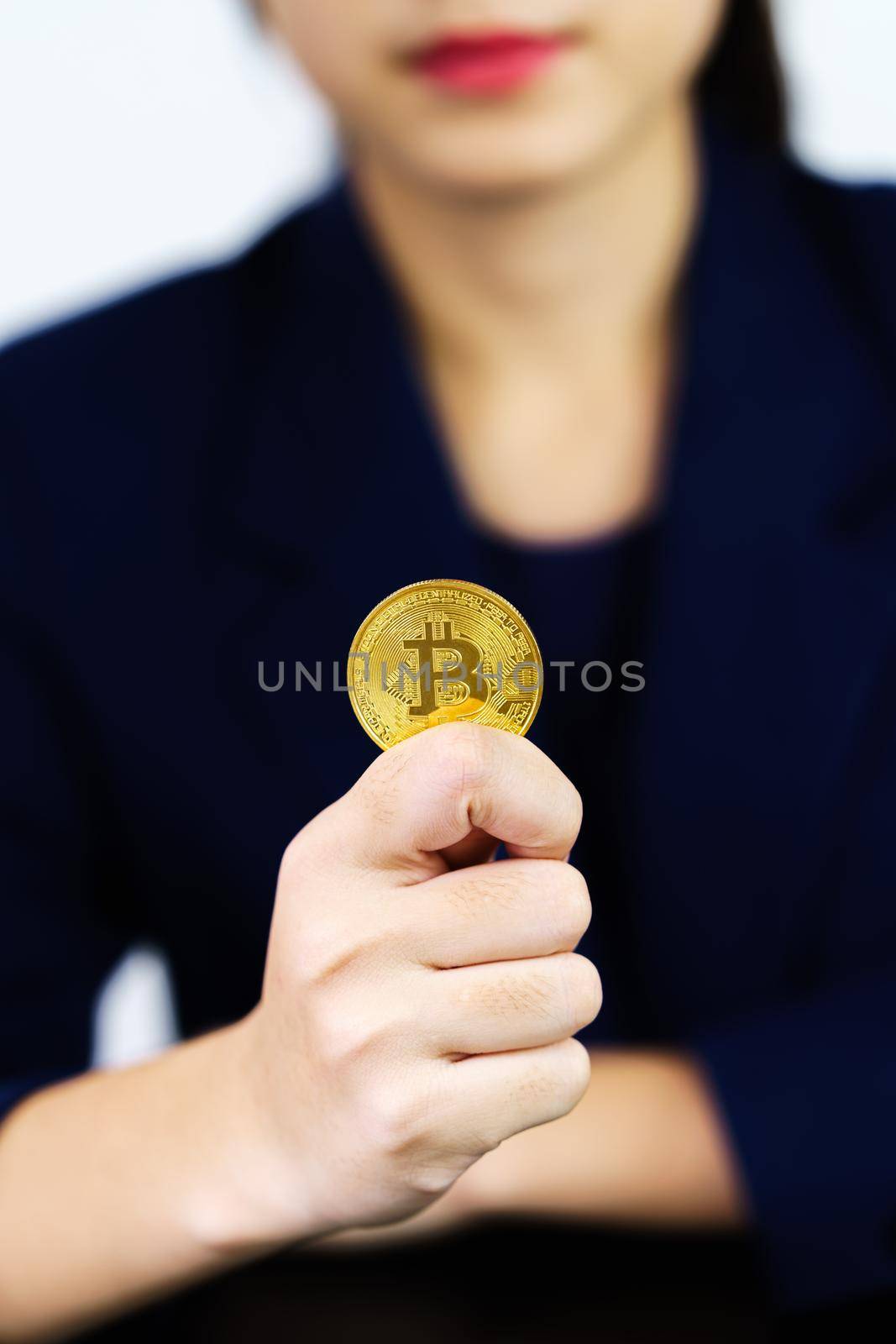 Close up businesswoman holding some pieces of golden Bitcoin token by stoonn