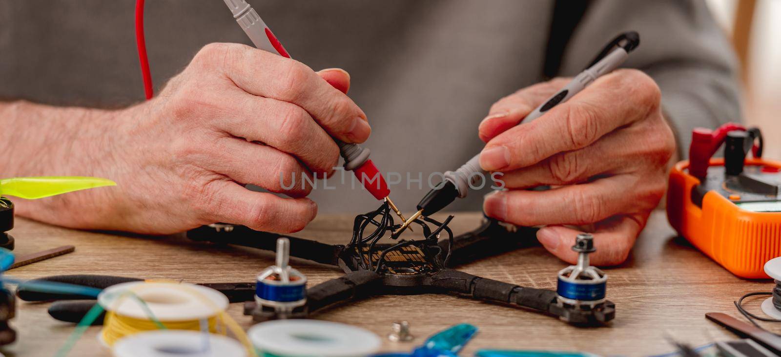 Closeup view of cheking recharge on quadcopter wires during repairing process