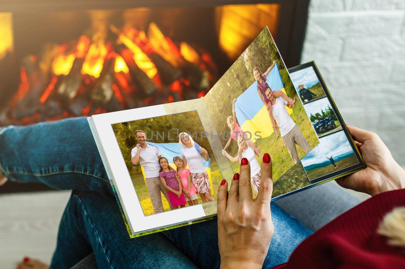 Family photos archive saved in brightly designed photo book; bright summer memories placed in the photobook. family with flag of ukraine.