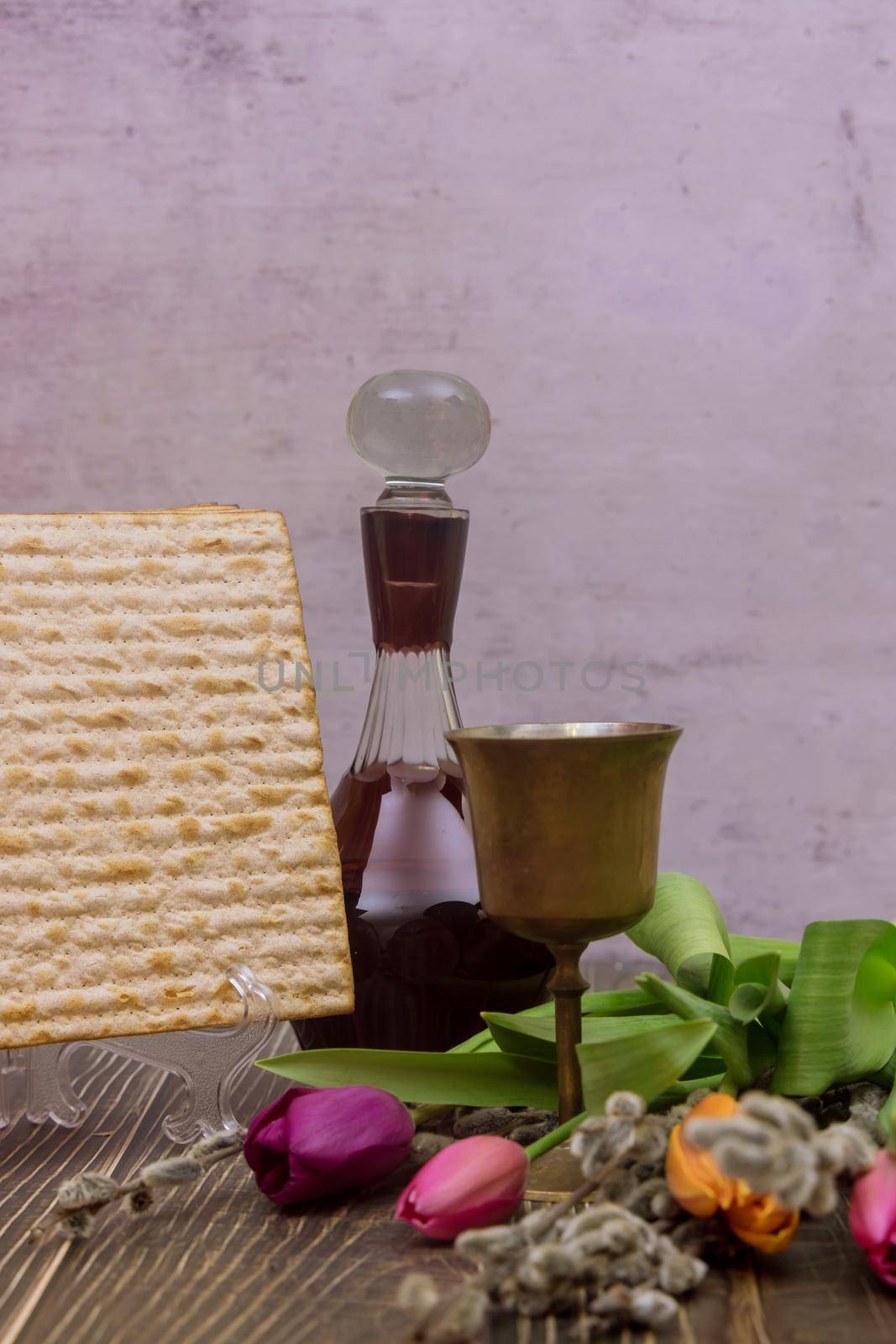Jewish Passover holiday on matzah bread with kosher wine kiddush and flowers