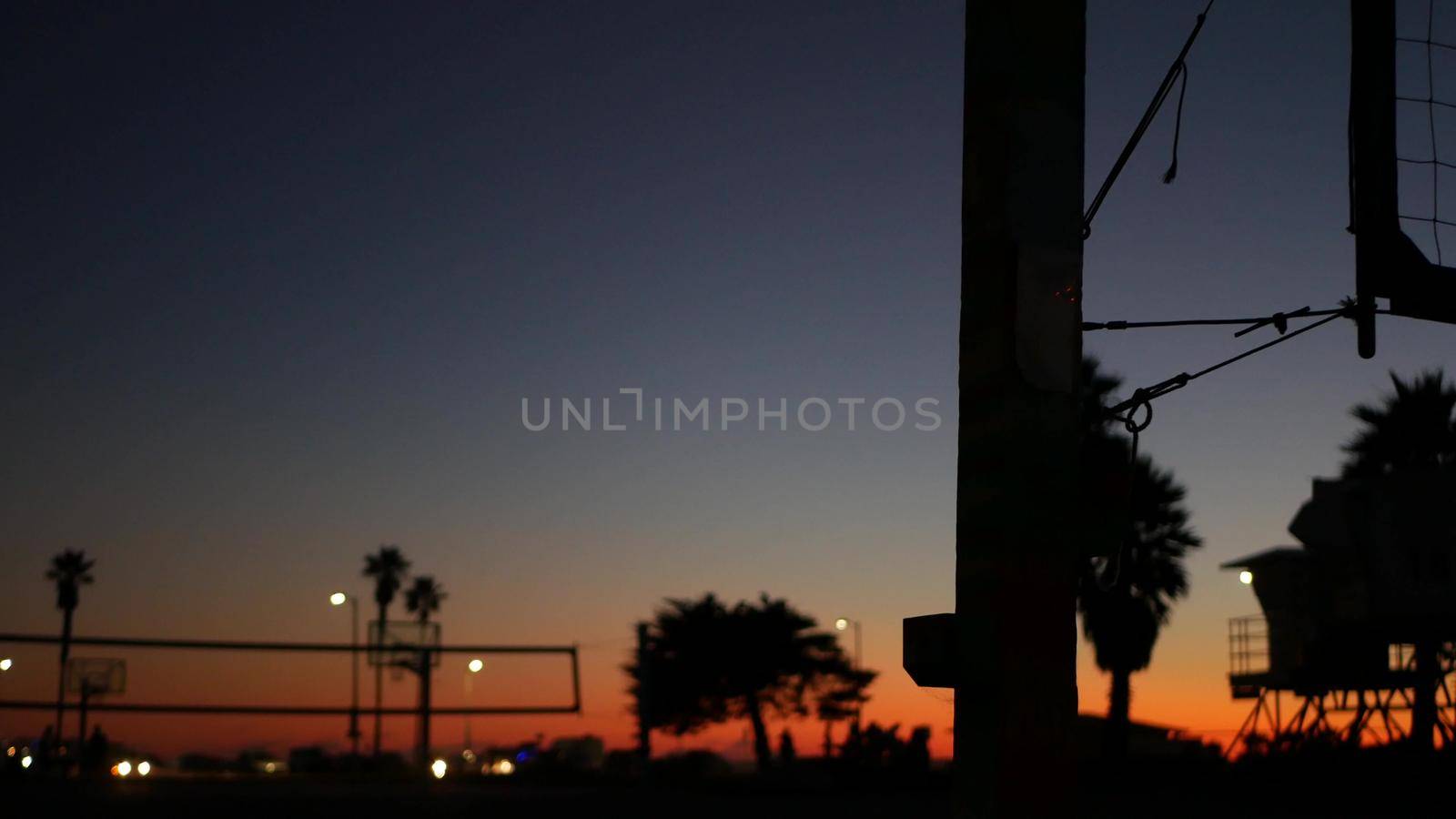 Volleyball net silhouette on beach sport court at sunset, California coast, USA. by DogoraSun