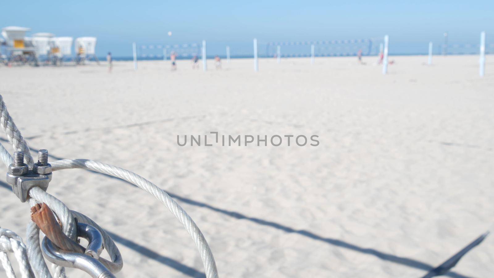 People playing volleyball on beach, lifeguard hut on sandy California coast, USA by DogoraSun