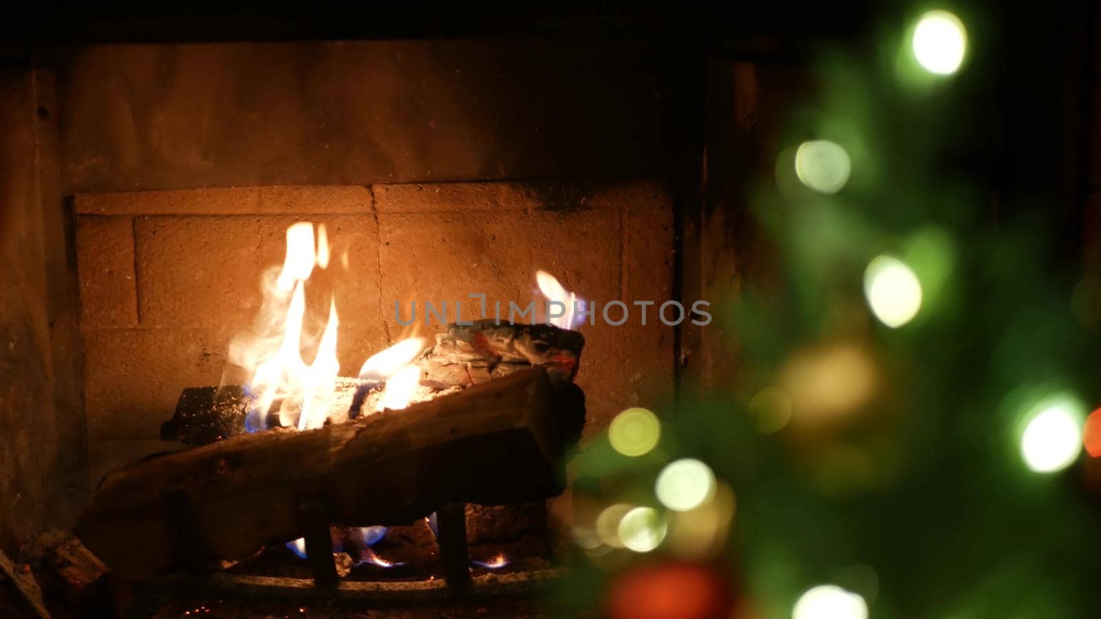 Christmas tree lights by fire in fireplace, New Years Eve or Xmas decoration. by DogoraSun