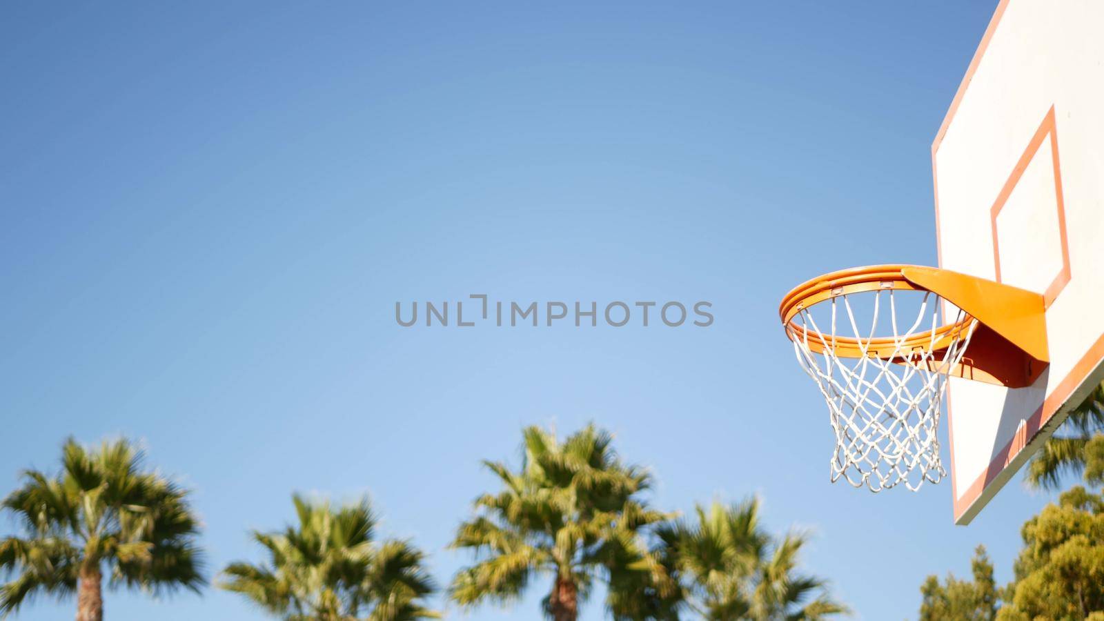 Basketball court outdoors, orange hoop, net and backboard for basket ball game. by DogoraSun