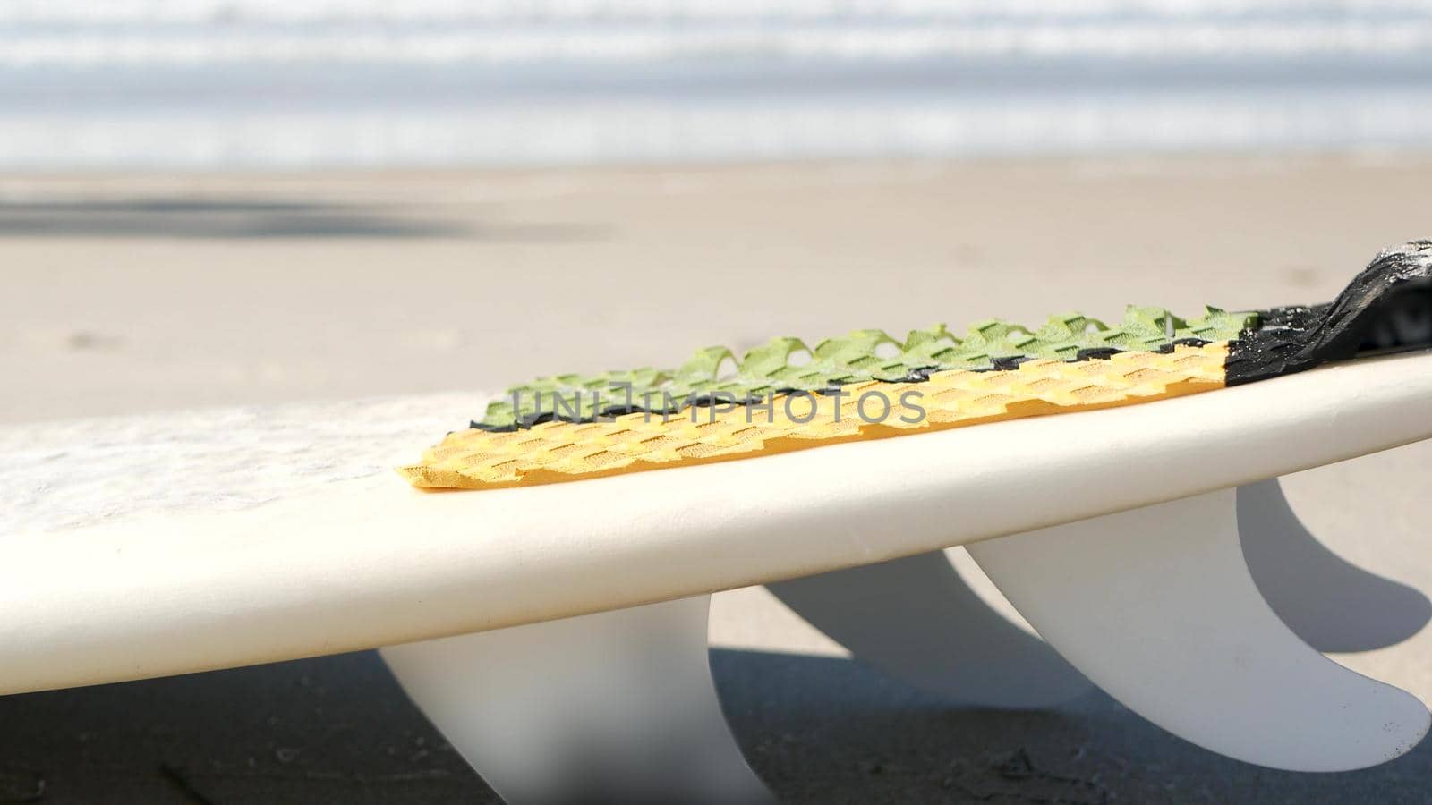 Surfboard for surfing lying on beach sand, California coast, USA. Ocean waves. by DogoraSun