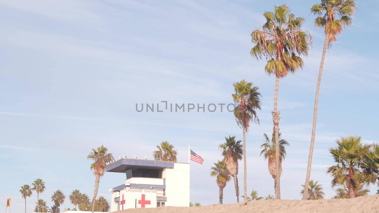Lifeguard stand, life guard tower hut, surfing safety on California beach, USA. Summer pacific ocean aesthetic. Rescue station, coast lifesavers wachtower or house, palm trees, Ocean Beach, San Diego.