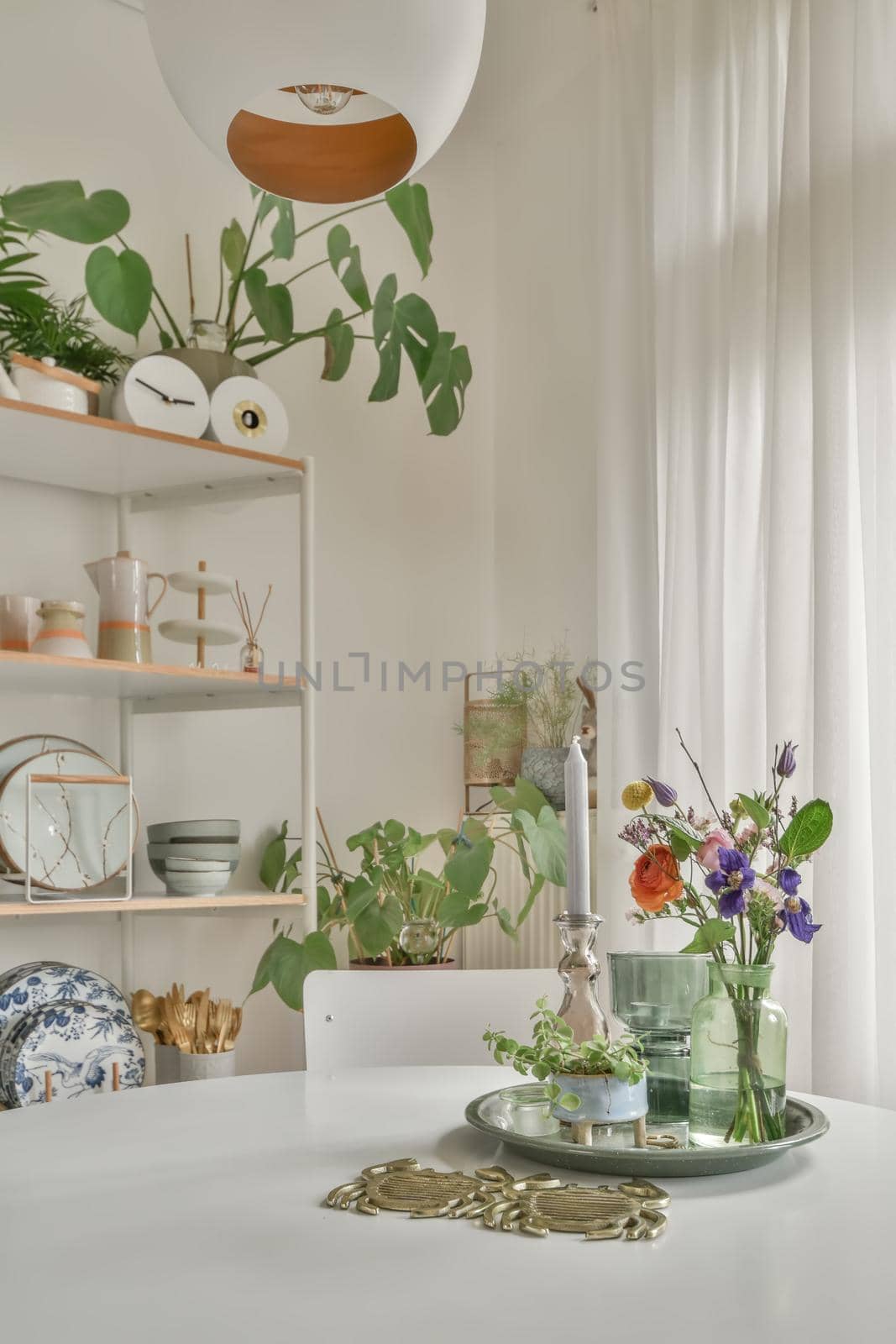 Home decoration using flowers, dishes and souvenirs located on shelves and table