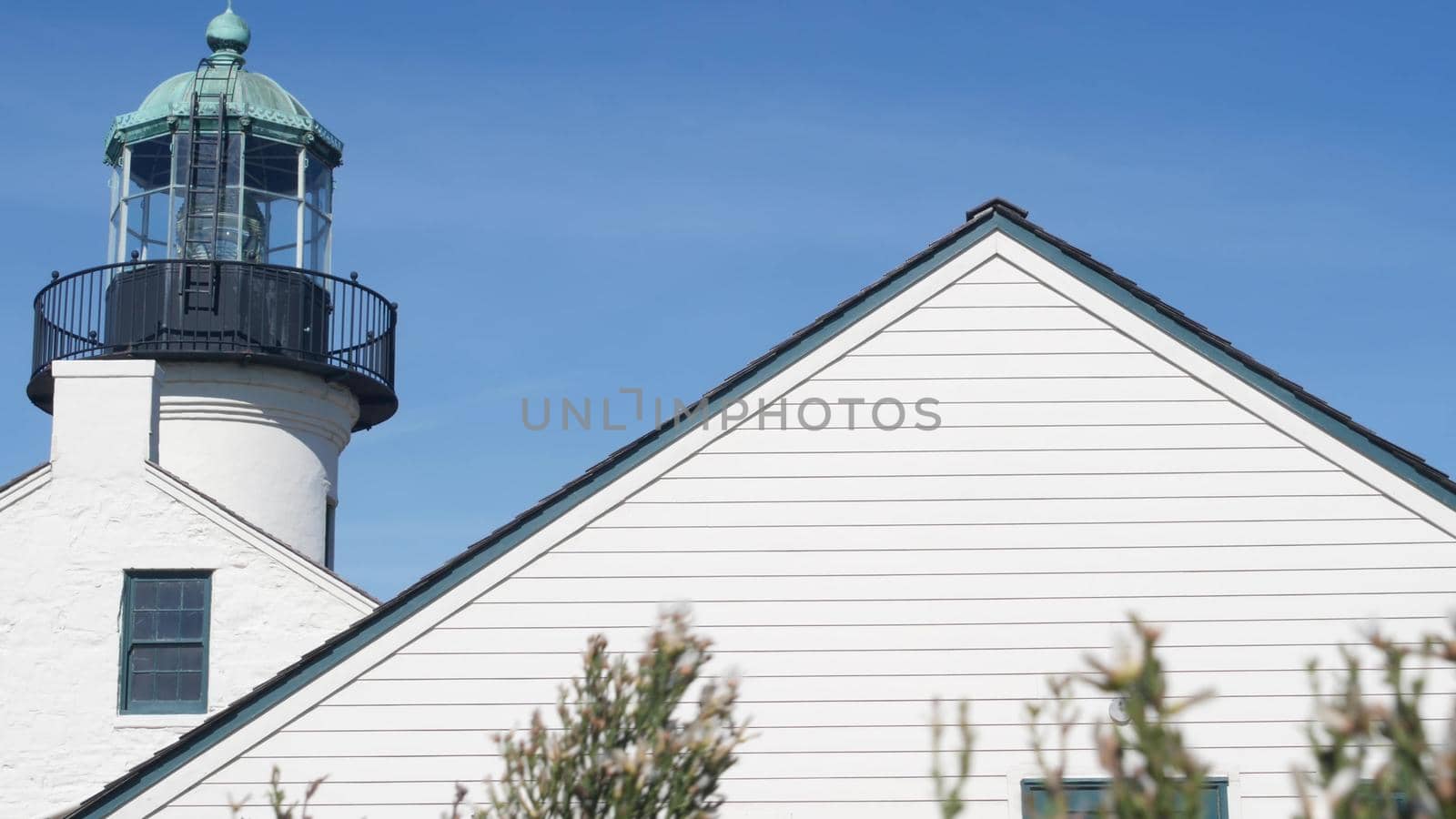Vintage lighthouse tower, retro light house, old fashioned historic classic white beacon with fresnel lens. Nautical navigational coastal building 1855. Point Loma, Cabrillo, San Diego, California USA