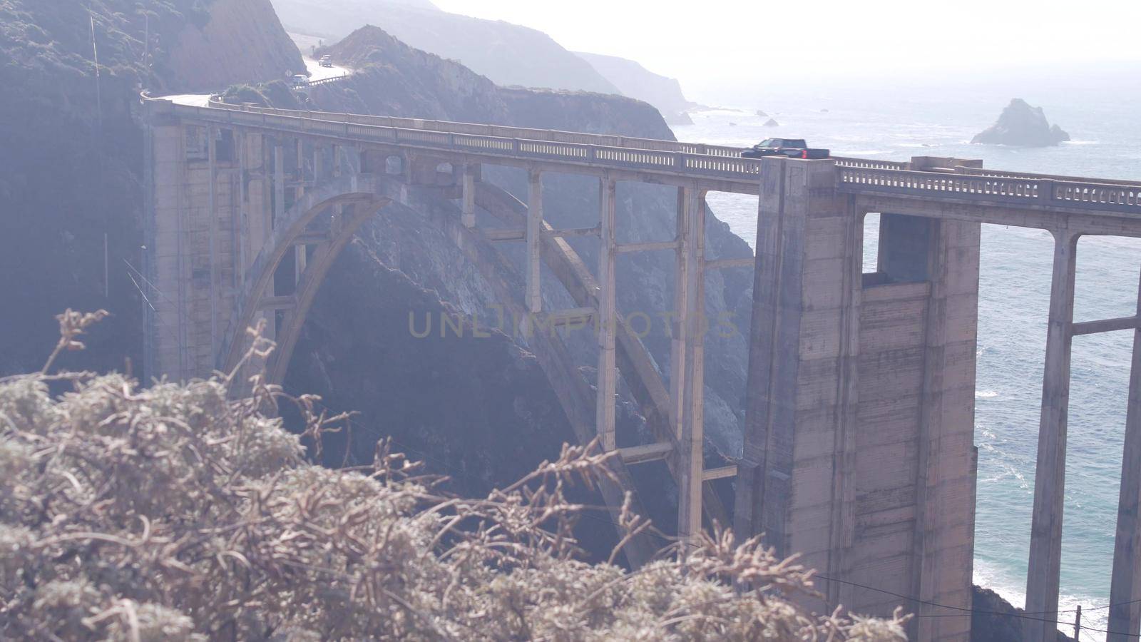 Bixby creek bridge, arch architecture. Pacific coast highway 1 landmark. Historic scenic Cabrillo road. Coastal road trip, journey or travel by ocean. Canyon in foggy weather. California, Big Sur, USA