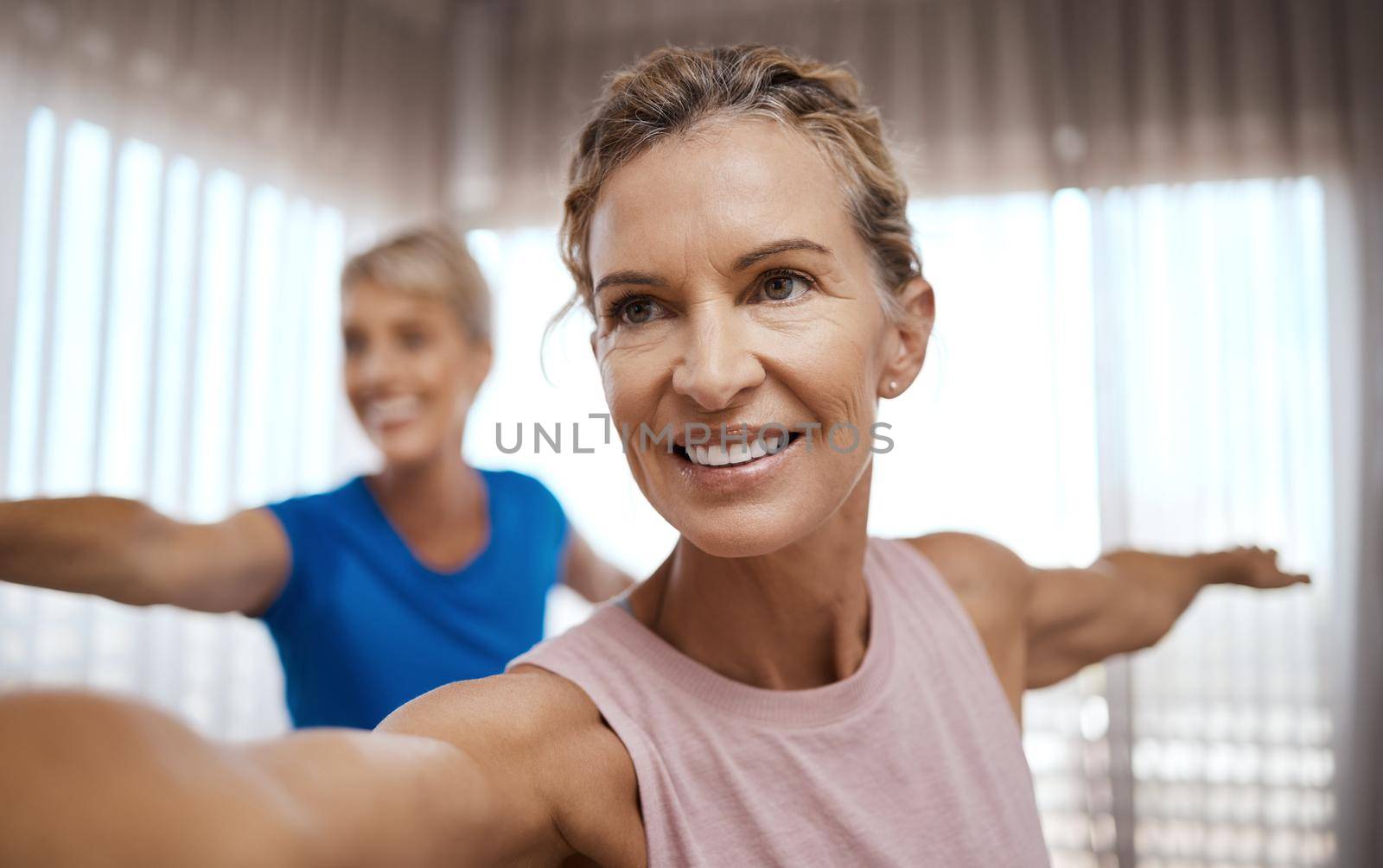 Shot of two mature women exercising together at home.