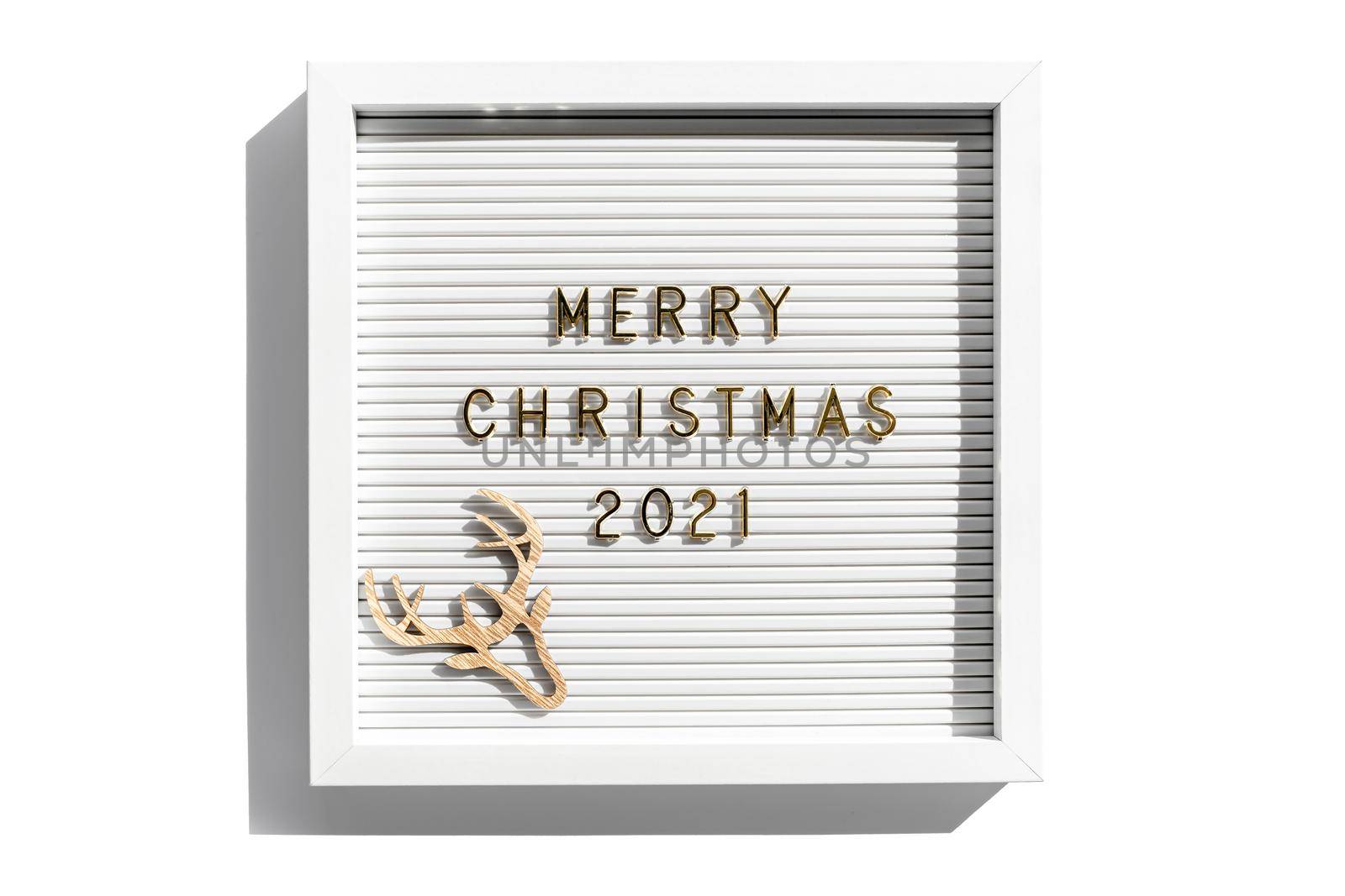 Letter board with Merry Christmas 2021 greeting, greeting quote on letterboard on white backdrop. Flat lay, from above by photolime