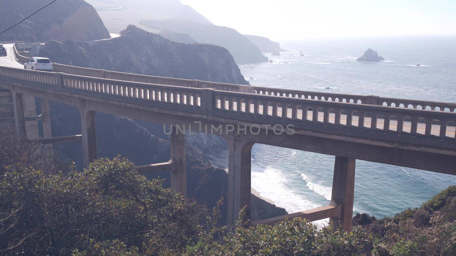 Bixby creek bridge, arch architecture. Pacific coast highway 1 landmark. Historic scenic Cabrillo road. Coastal road trip, journey or travel by ocean. Canyon in foggy weather. California, Big Sur, USA