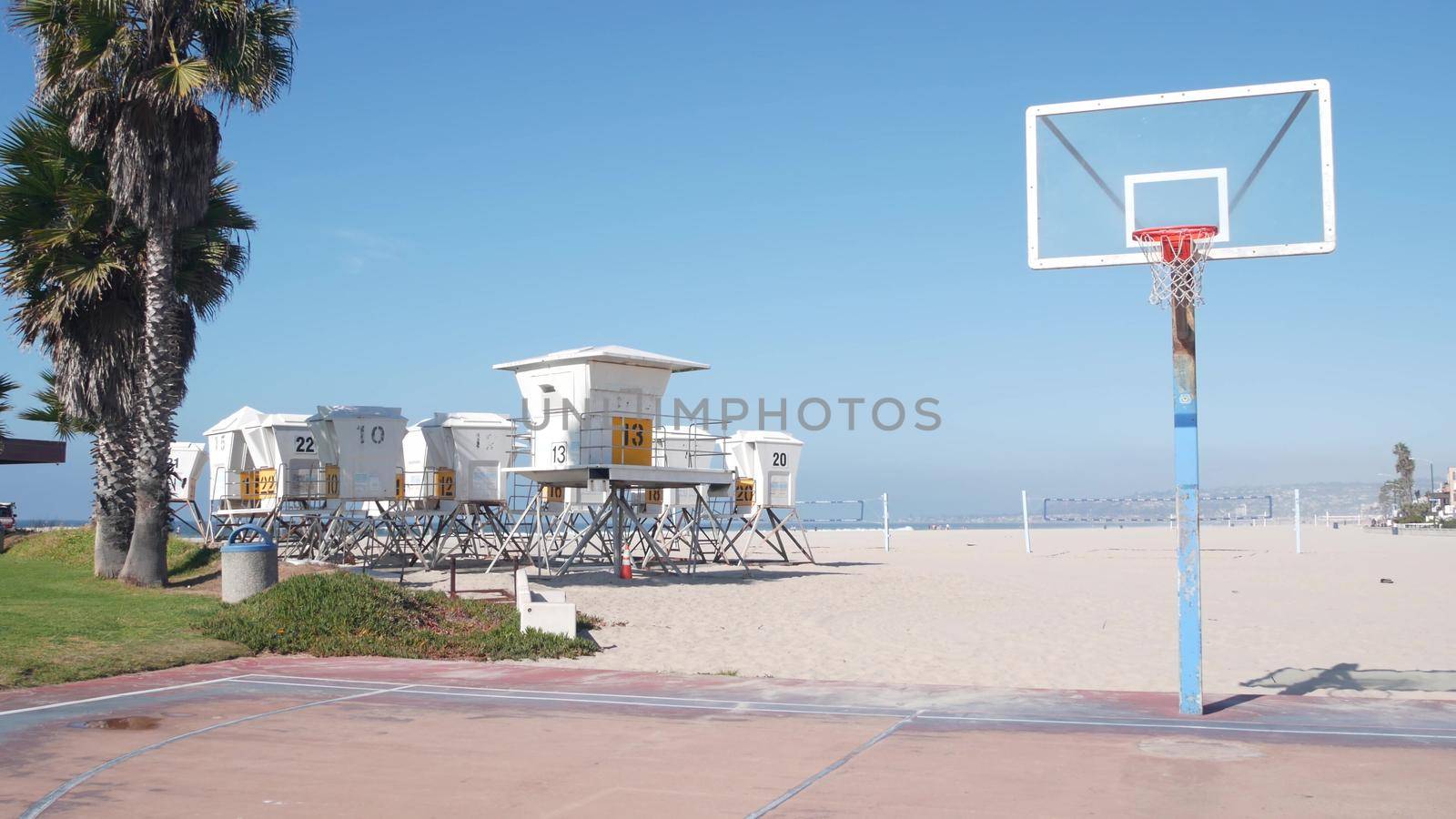 Palm trees and basketball sport field or court on beach, California coast, USA. by DogoraSun