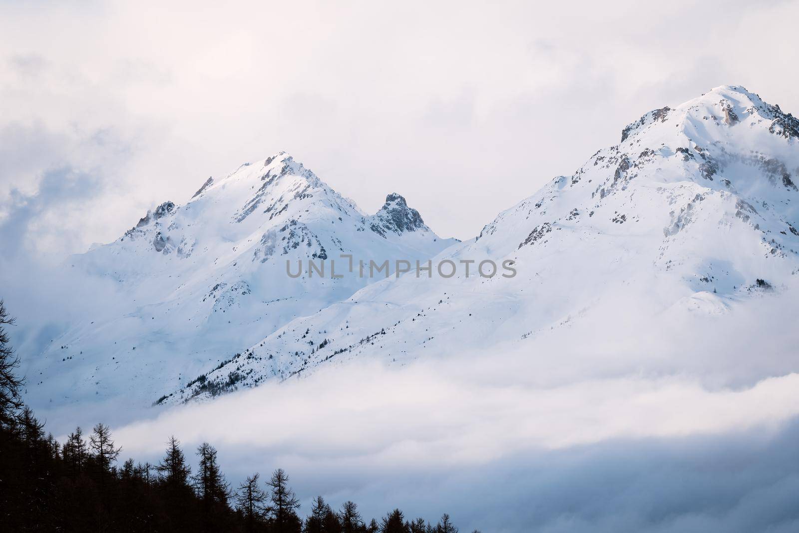 Foggy winter mountain landscape. Panoramic view of mountains near Brianson, Serre Chevalier resort, France. Ski resort landscape. Snowy mountains. Misty morning in mountains by photolime