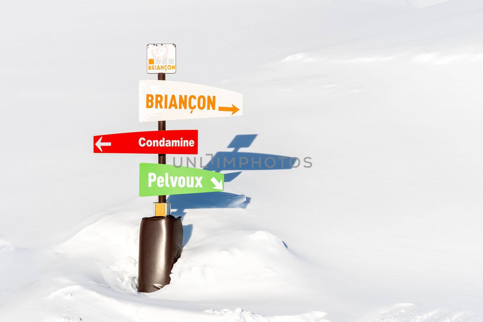 Directional board post at ski resort on sunny winter day by photolime