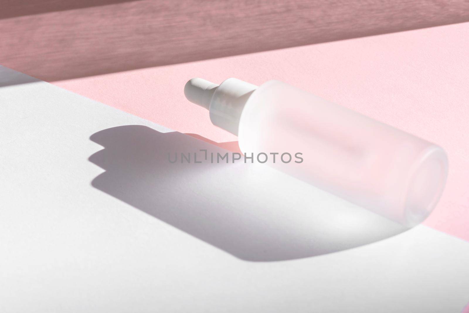 Serum oil with collagen and peptide in white transparent bottle with dropper on pink backdrop with shadows. Skincare beauty treatment medical skincare mockup packaging liquid cosmetic product