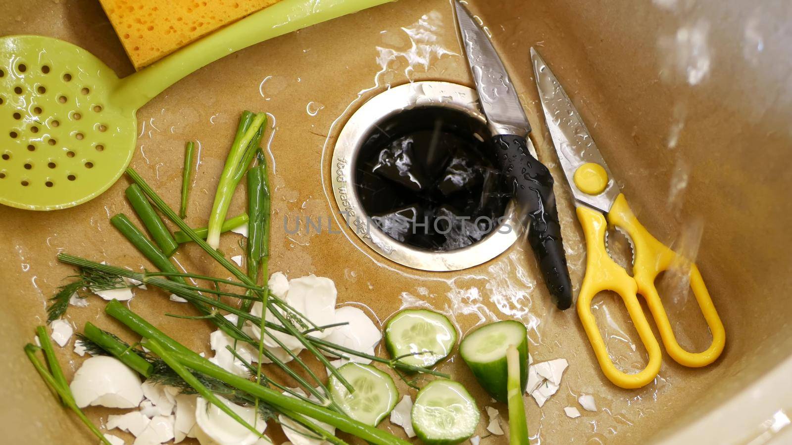 Organic garbage in sink with built-in food waste disposer. vegetable or fruits peels, remains and leftovers and disposal grinder. Zero waste, sustainable development and garbage separation concept.