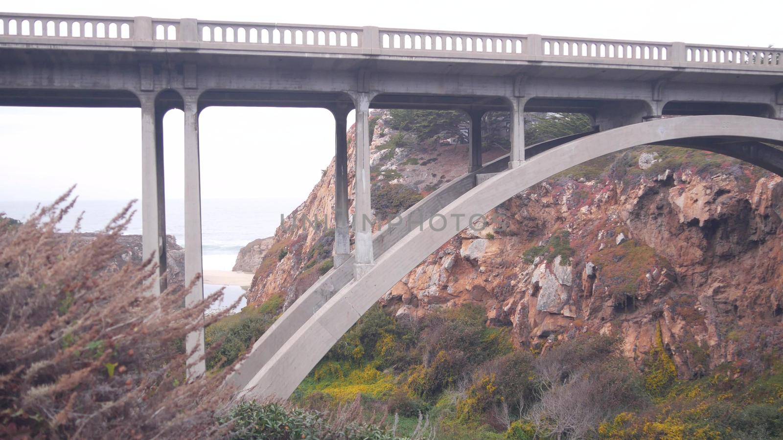 Arch bridge over river creek in canyon, pacific coast highway, California road. by DogoraSun