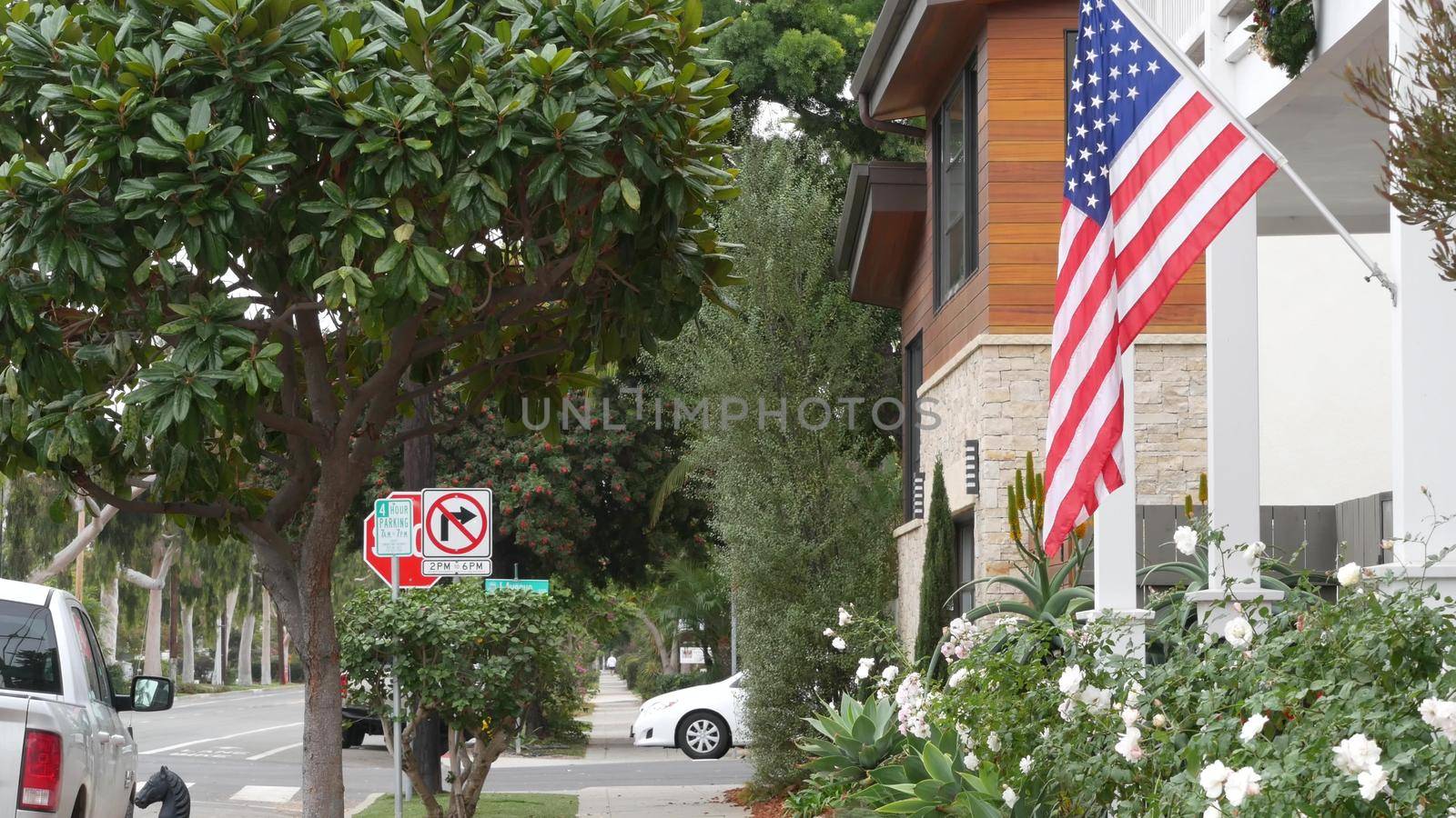 American flag waving, suburban house facade residential district, California USA by DogoraSun