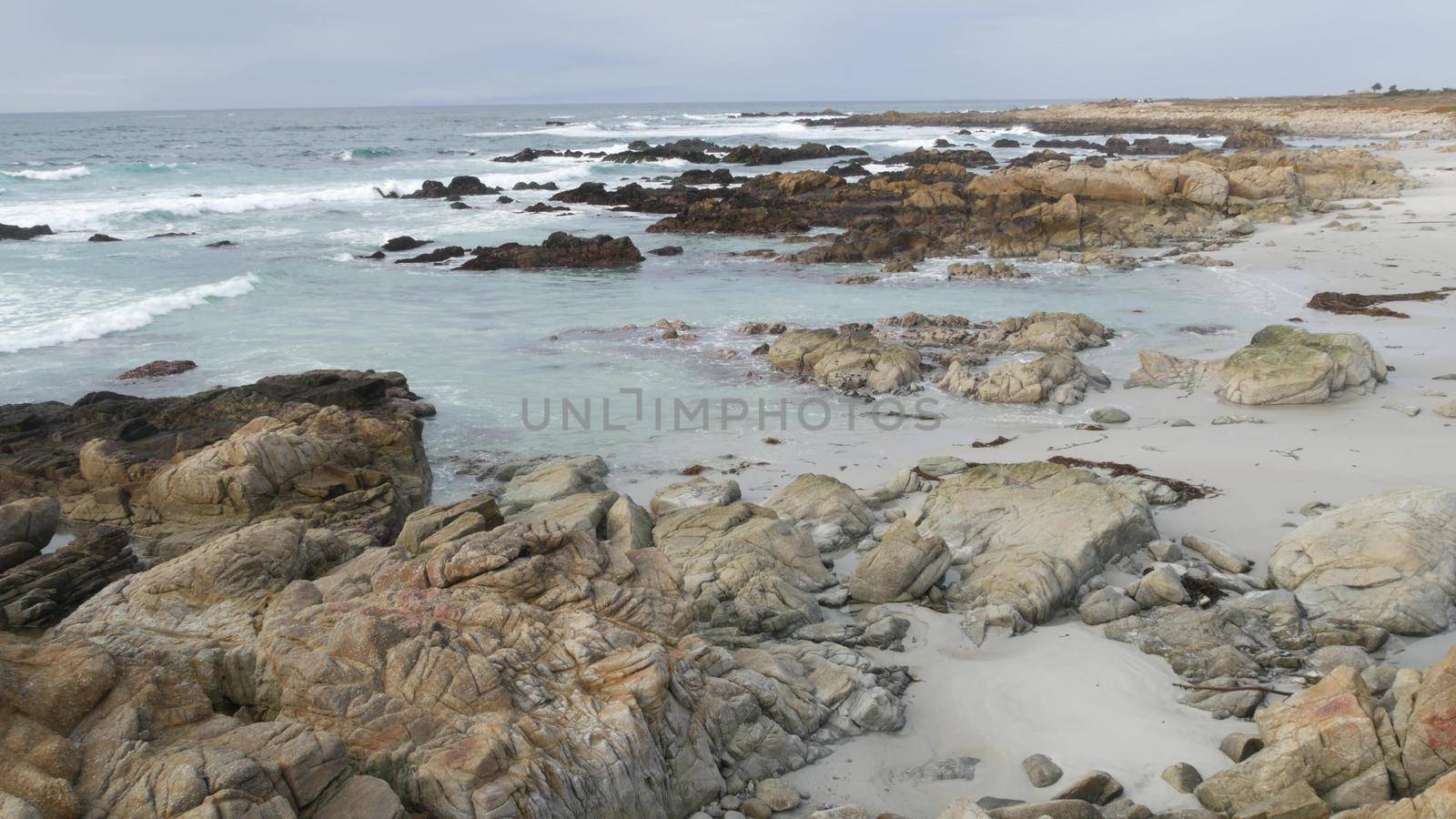 Rocky craggy ocean coast, sea water waves crashing on rocks, Monterey California by DogoraSun