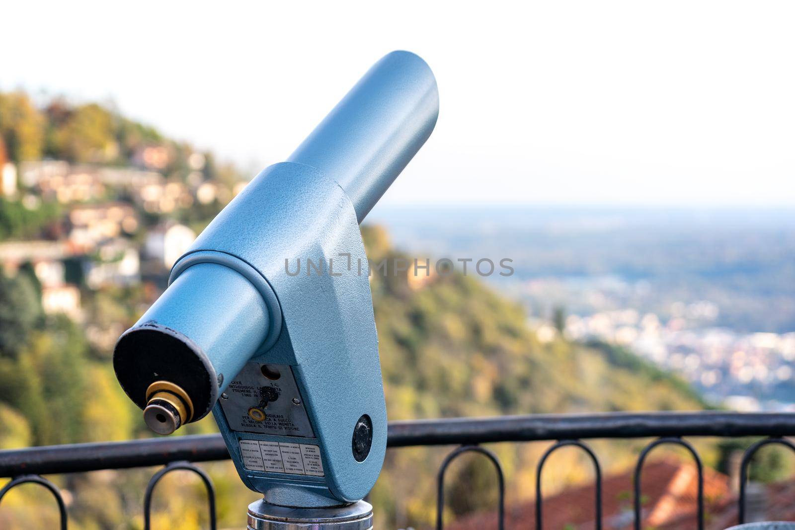 Spyglass looking out to the mountains in Como, Italy. Coin operated monocular viewer. Zoom landscape in point of view