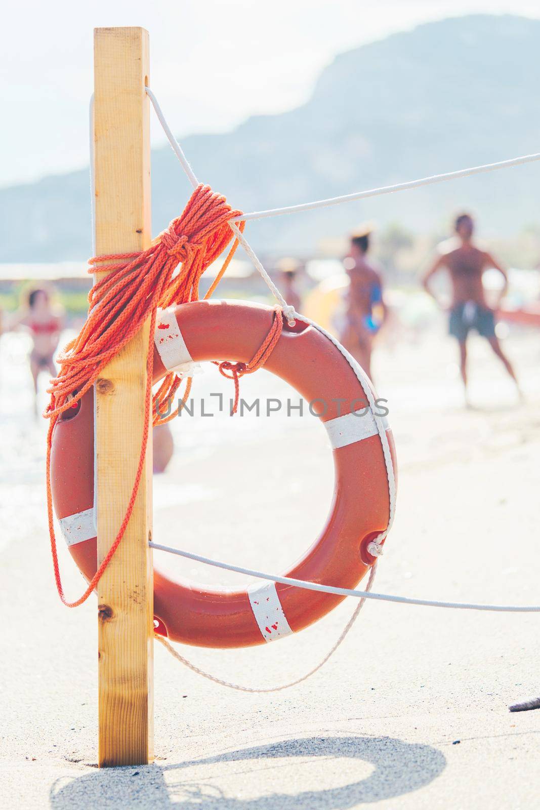 Life saver rescue ring with rope on the beach in case of emergency. Life saving lifeguard buoy. Italy, Finale ligure - August 23, 2020