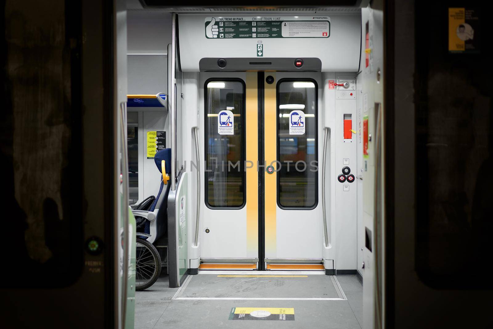 Doors of wagon in railway station of Milan, electric train carriage interior with an open sliding mechanical door. Milan, Italy - December 15, 2020 by photolime