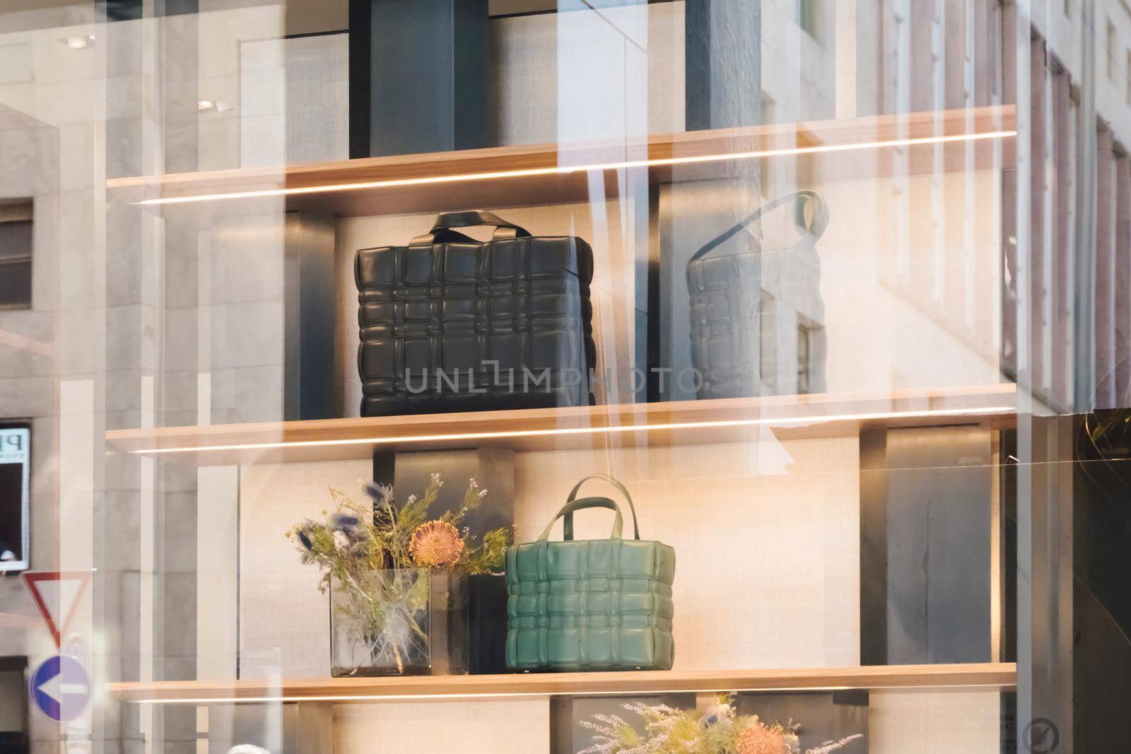 Women luxury handbags in a store in Milan. Fashion shop display. Luxury store appearance. Showcase window. Stylish woman's bags on shelf of boutique. Milan, Italy - September 24, 2020. .