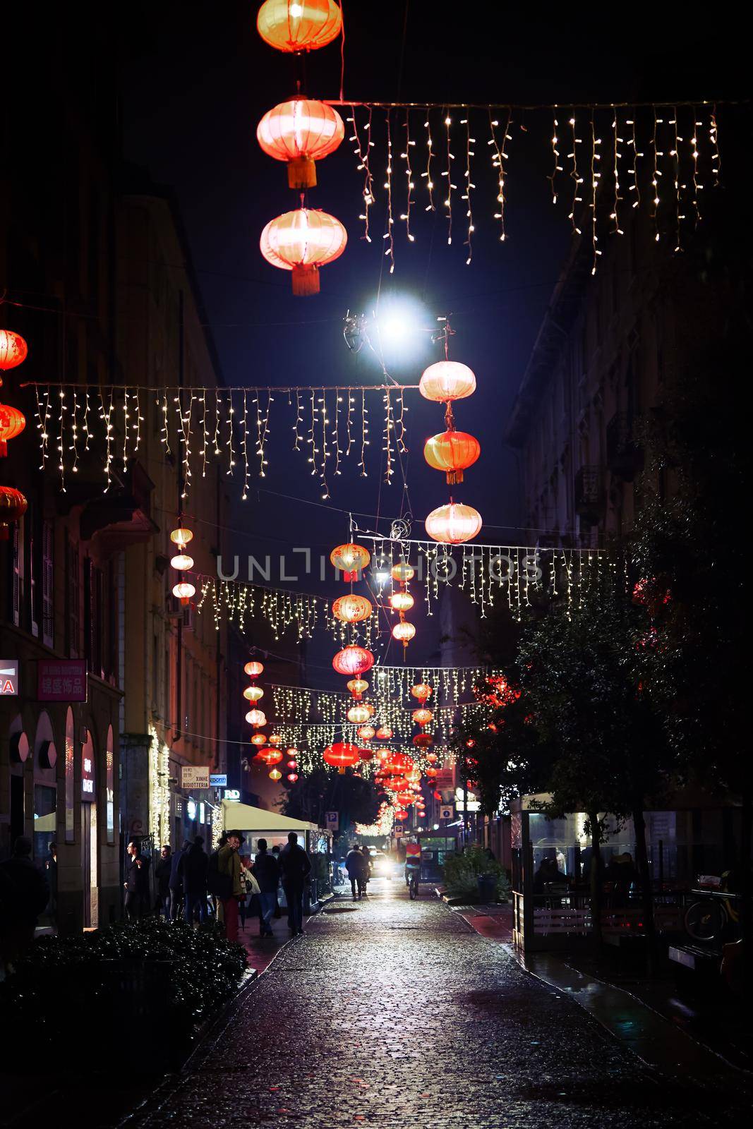 Chinese new year red lanterns in Chinatown. Decorations on the street in night time. Milan, Italy - December, 12, 2019