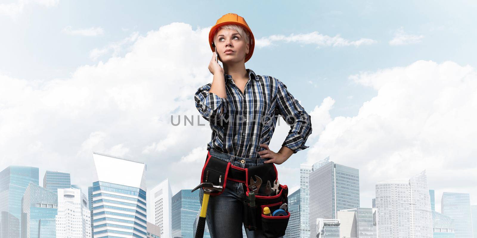 Attractive woman in workwear and hardhat by adam121