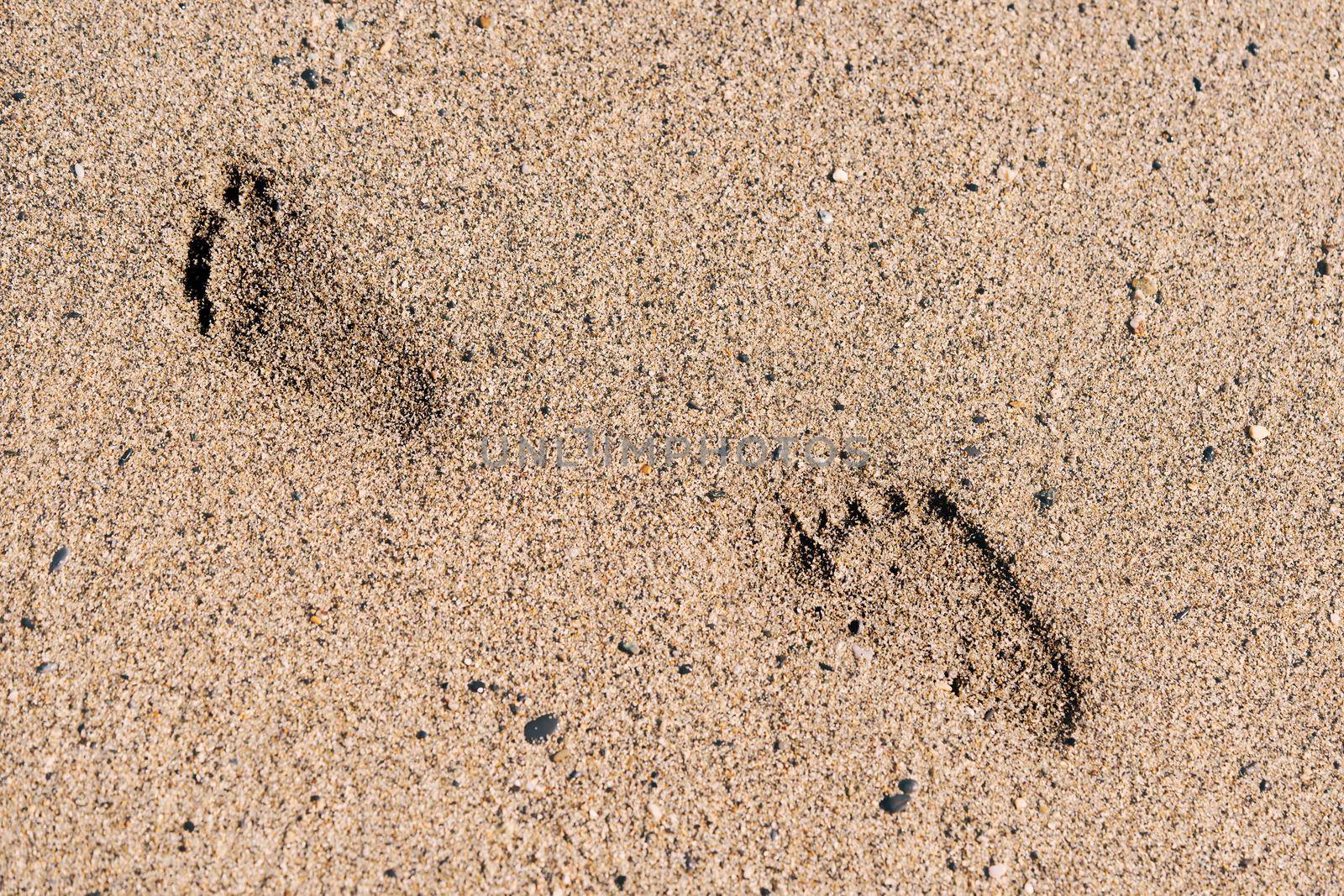 Child's footprints at the sandy beautiful beach by photolime