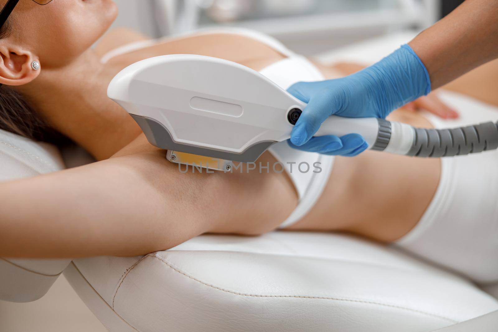 Closeup of armpit hair laser removal procedure with ipl machine in a beauty salon by Yaroslav_astakhov