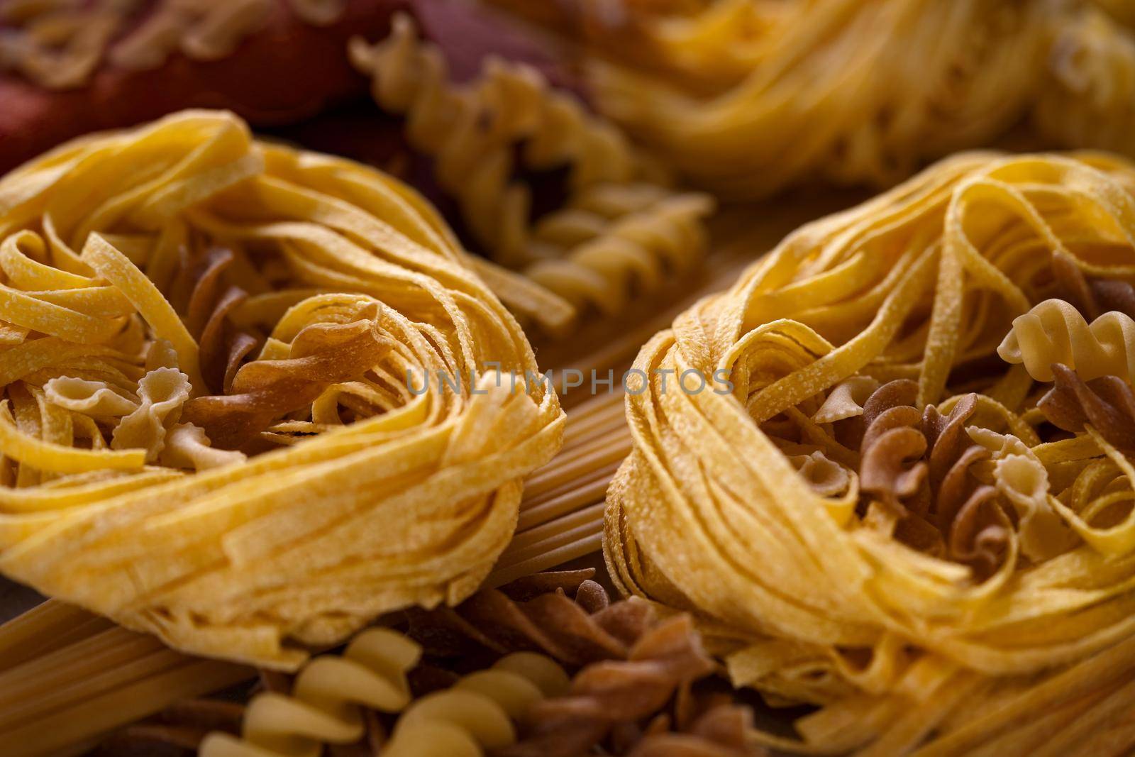 Different types of italian pasta. Spaghetti, tagliatelle, fusilli, pappardelle, fettuccine. Uncooked pasta set made unleavened dough of wheat flour by photolime