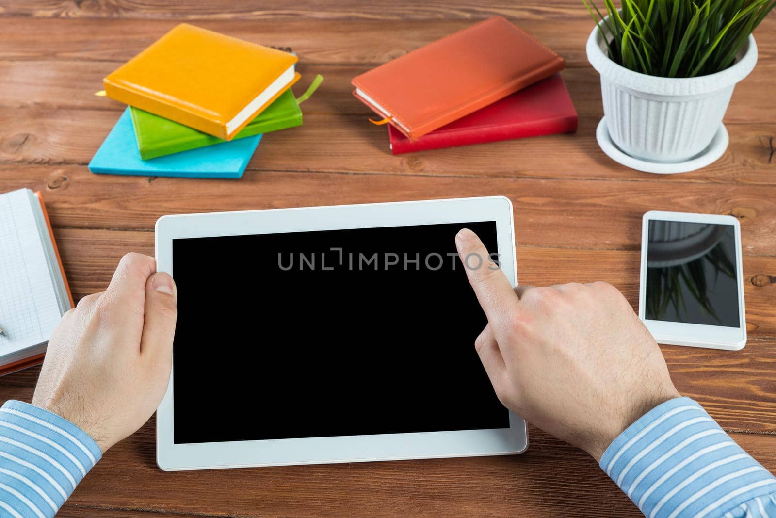 close-up of men's hands with a computer tablet. Businessman works in the office