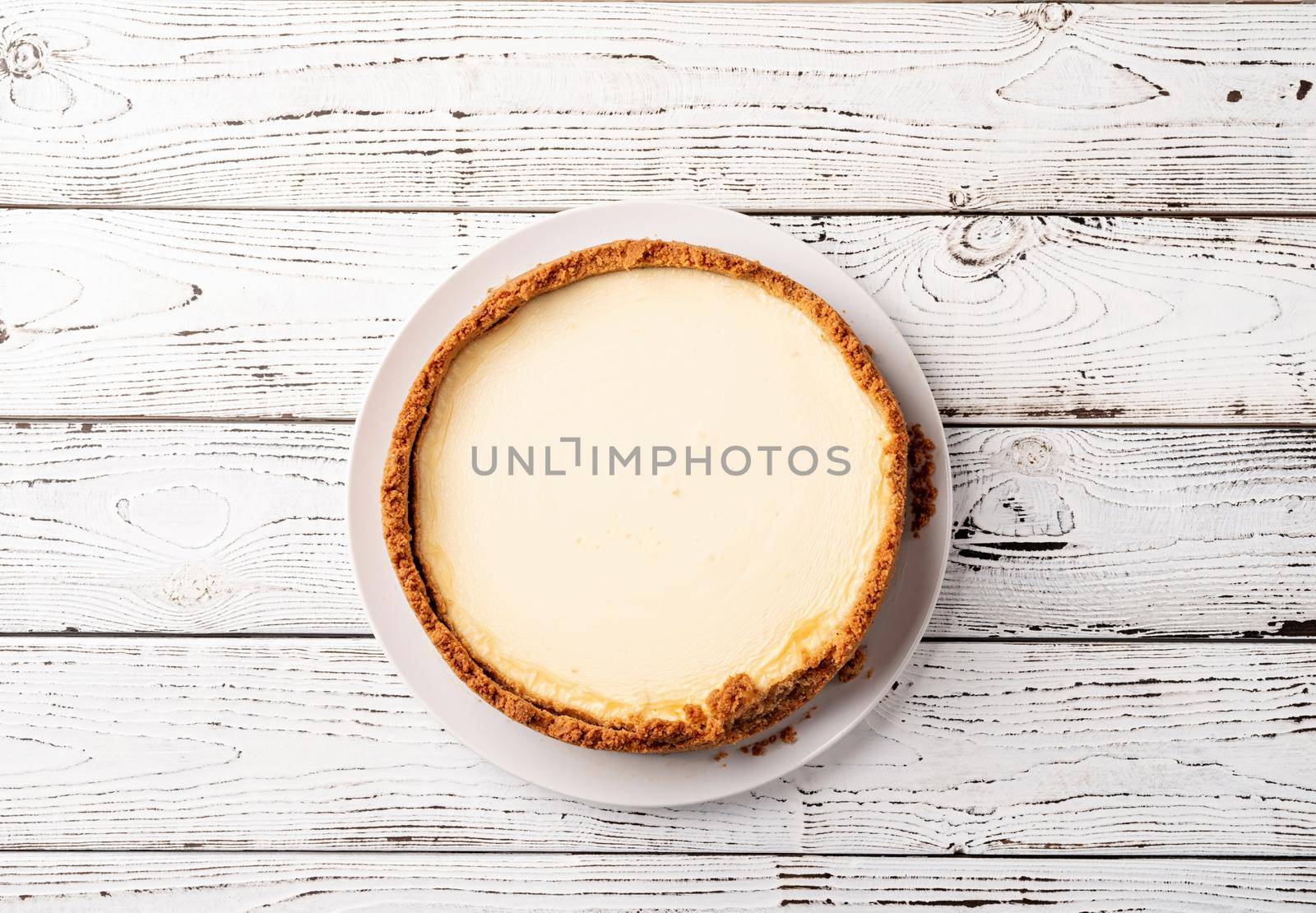 Tasty homemade cheesecake on white wooden table with copy space