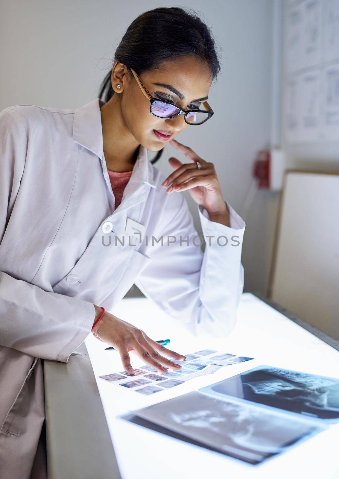 Cropped shot of a young female dentist analysing an x-ray.