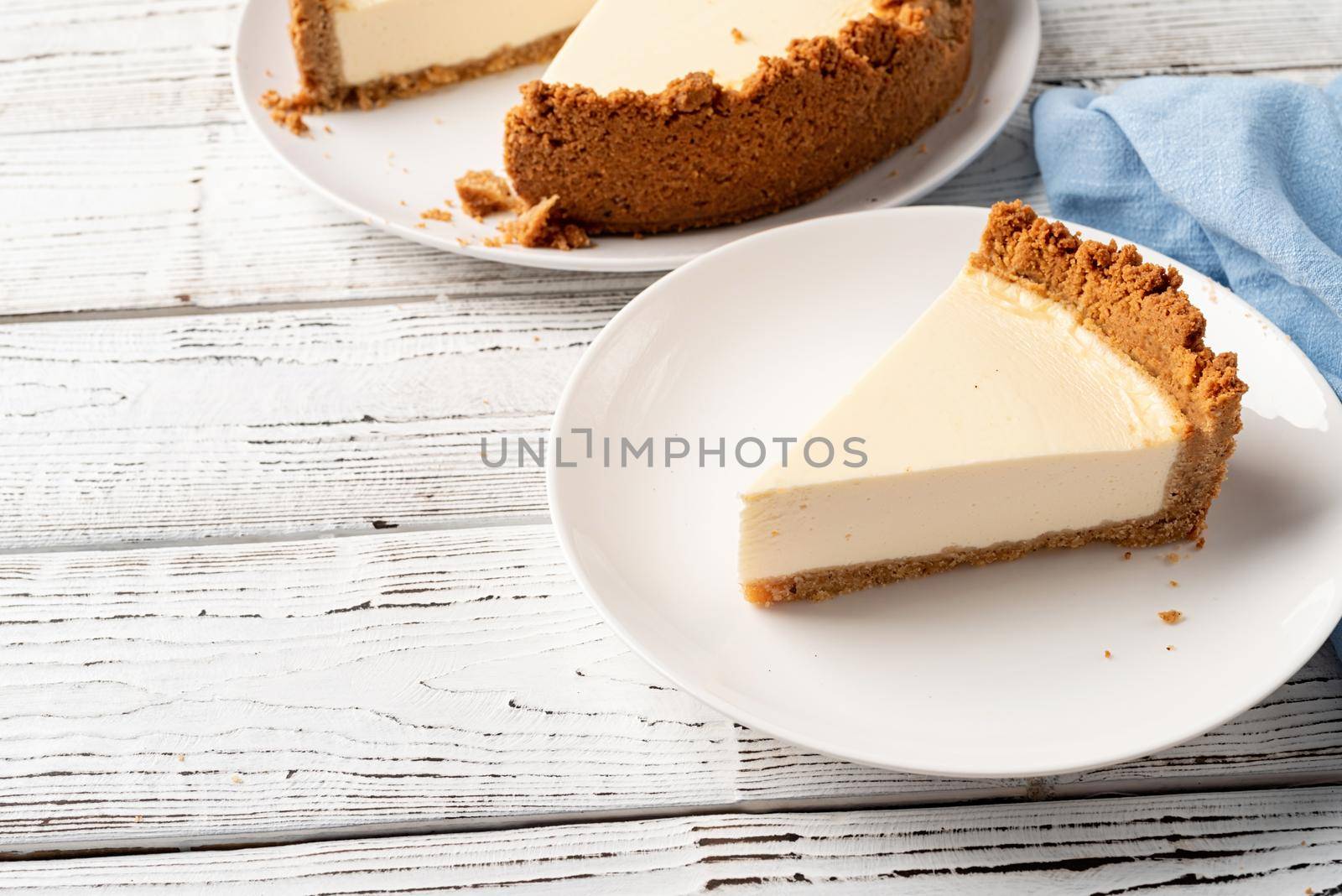Tasty homemade cheesecake on white wooden table with copy space