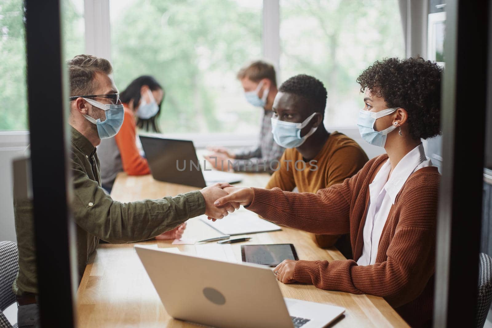business people in protective masks shaking hands. concept of coworking.