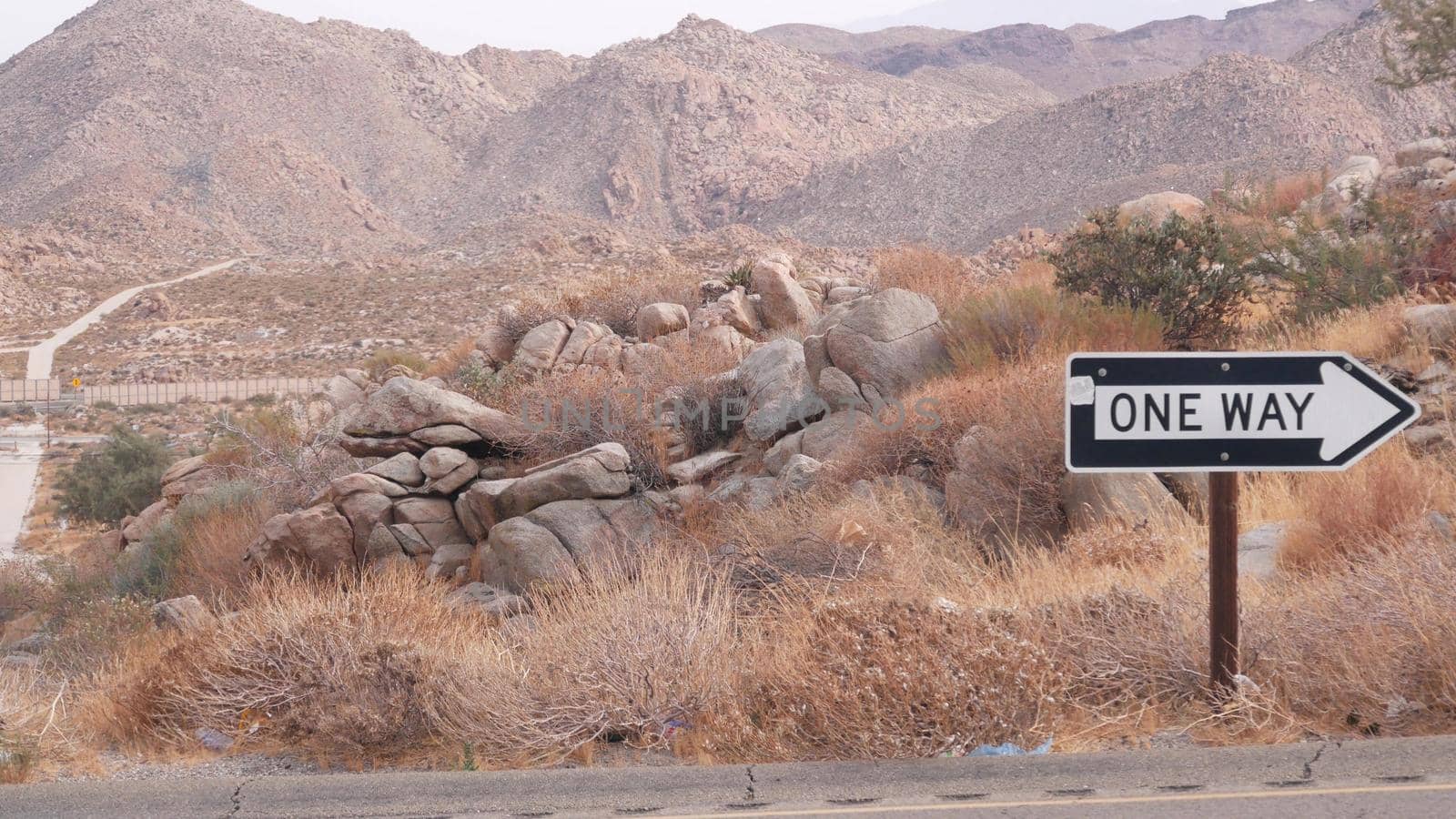One way road sign arrow, highway roadside in California, USA road trip in desert by DogoraSun