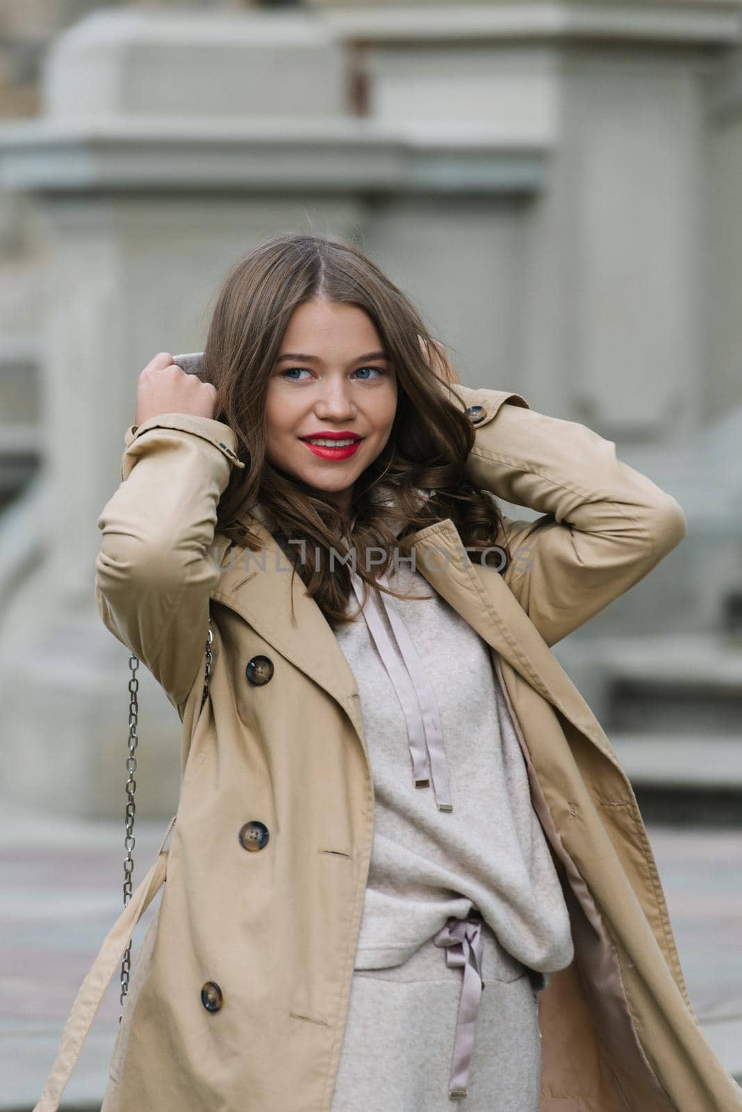 Portrait of fashionable women in beige sports suit and trench coat posing. street look fashion