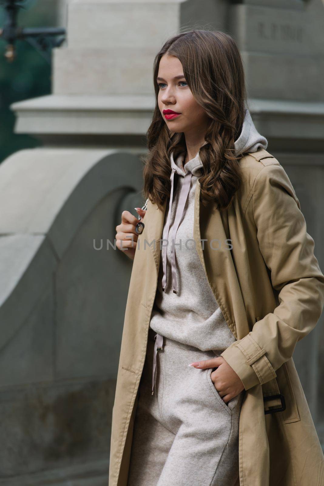 Portrait of fashionable women in beige sports suit and trench coat posing on the street by Ashtray25