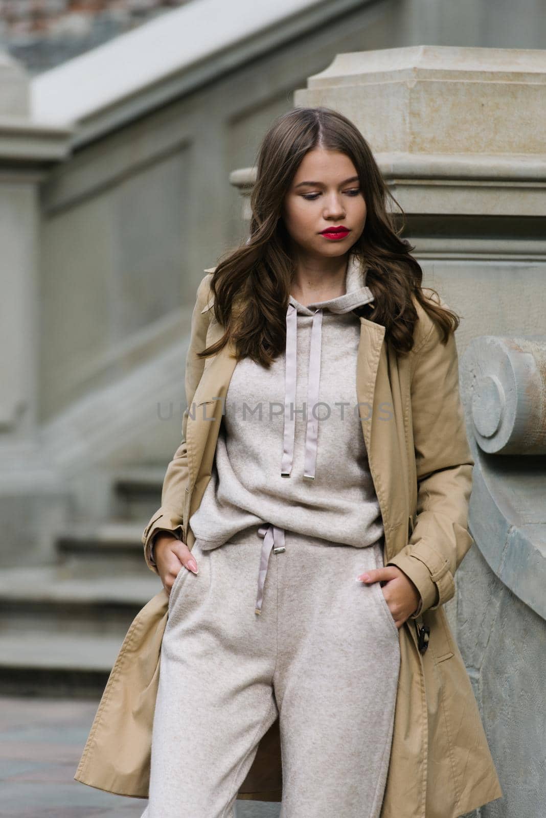 Portrait of fashionable women in beige sports suit and trench coat posing. street look fashion