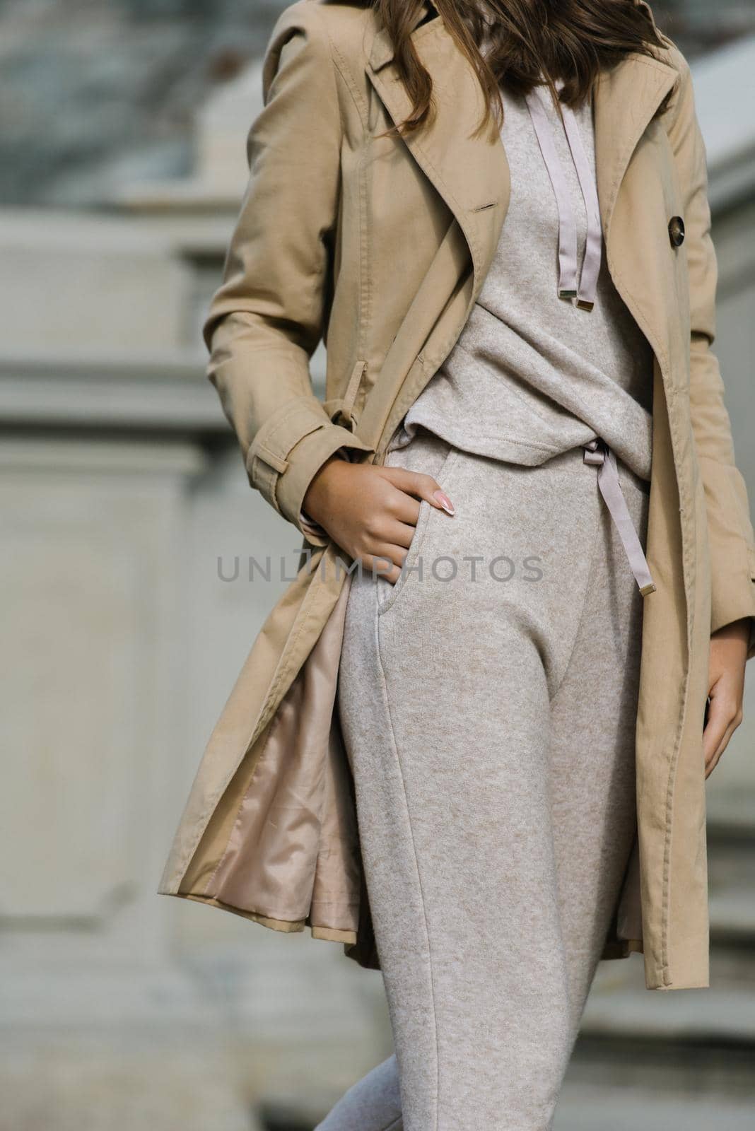 Portrait of fashionable women in beige sports suit and trench coat posing. street look fashion