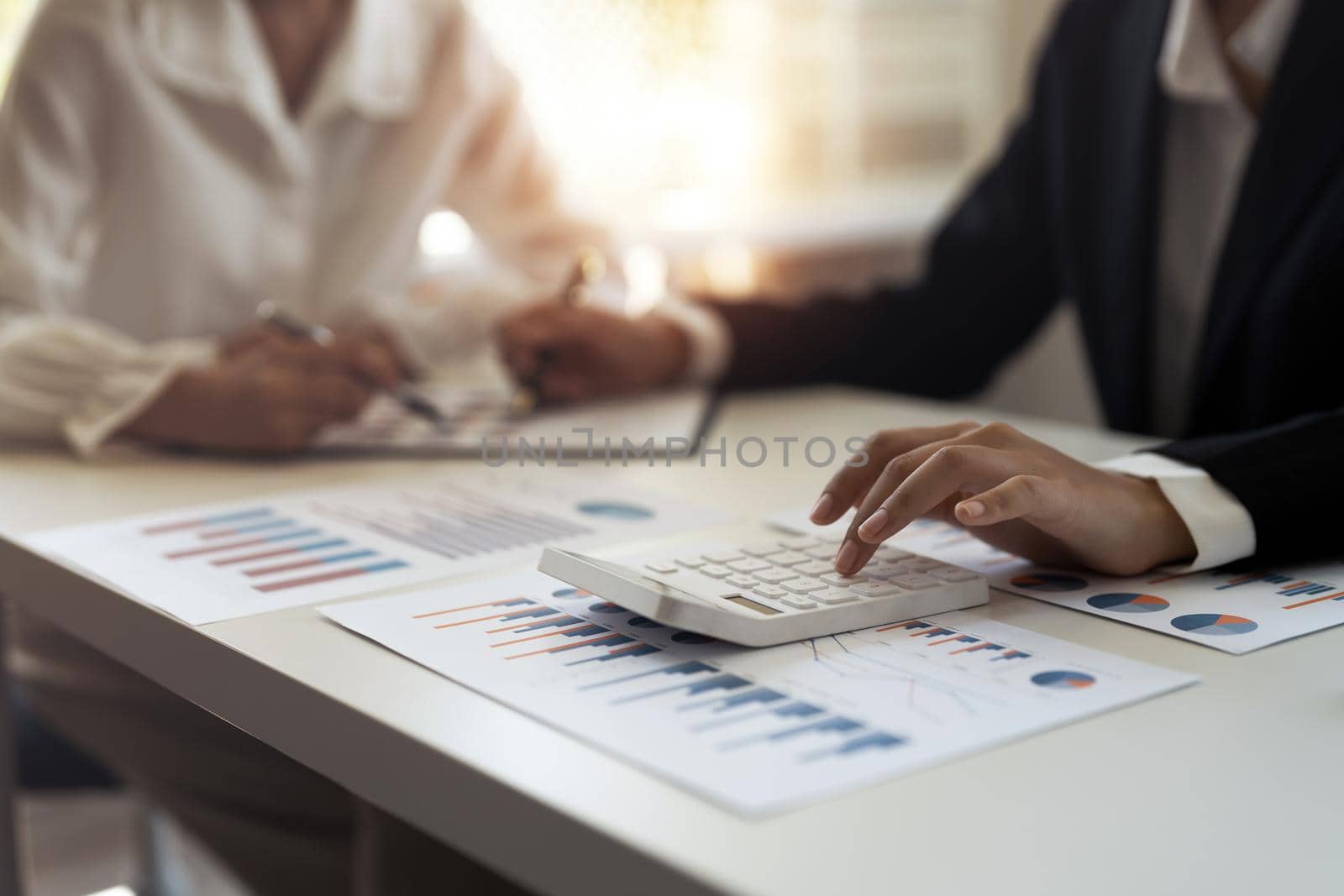 Close up Businessman and partner using calculator and laptop for calaulating finance, tax, accounting, statistics and analytic research concept.