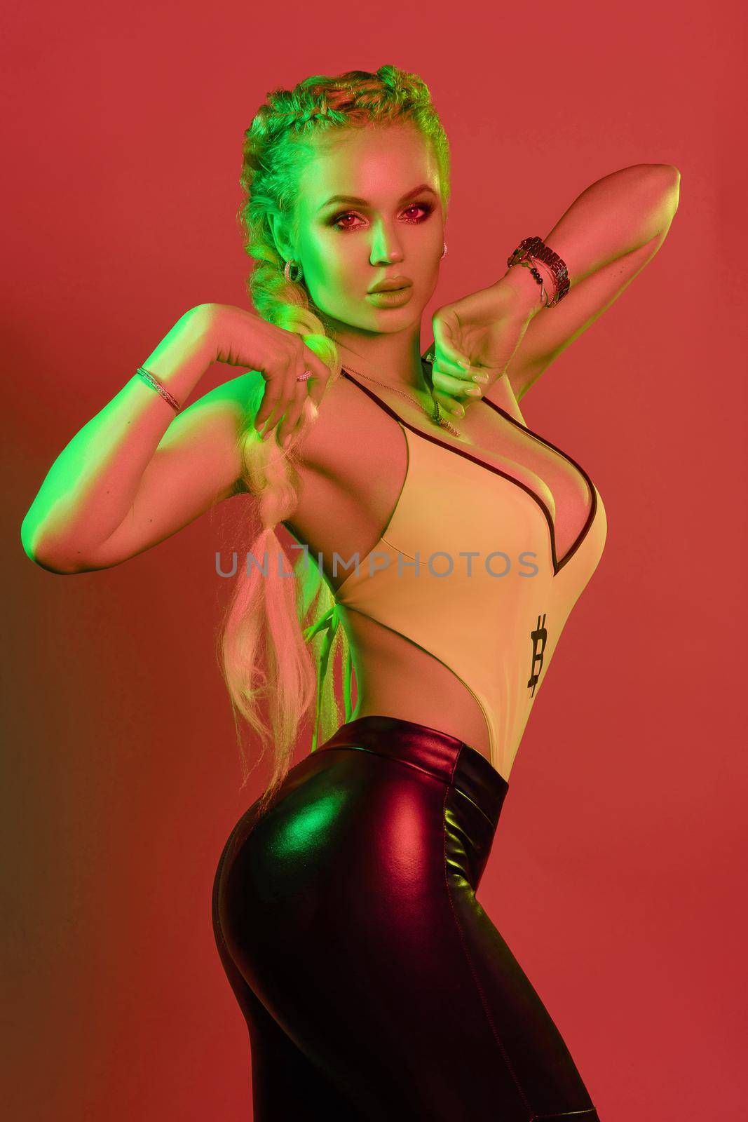 Side view of hot blonde in leggings and top looking at camera and posing on isolated background. Sexy woman with makeup doing sport, fitness and keeping fit. Concept of body and diet.