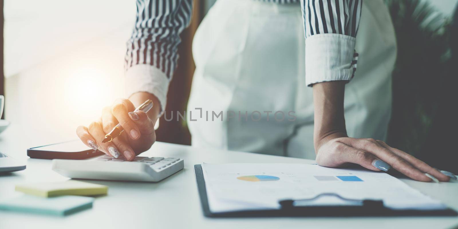 Consult financial concept. Business woman using calculator and pointing at papwework and using laptop computer