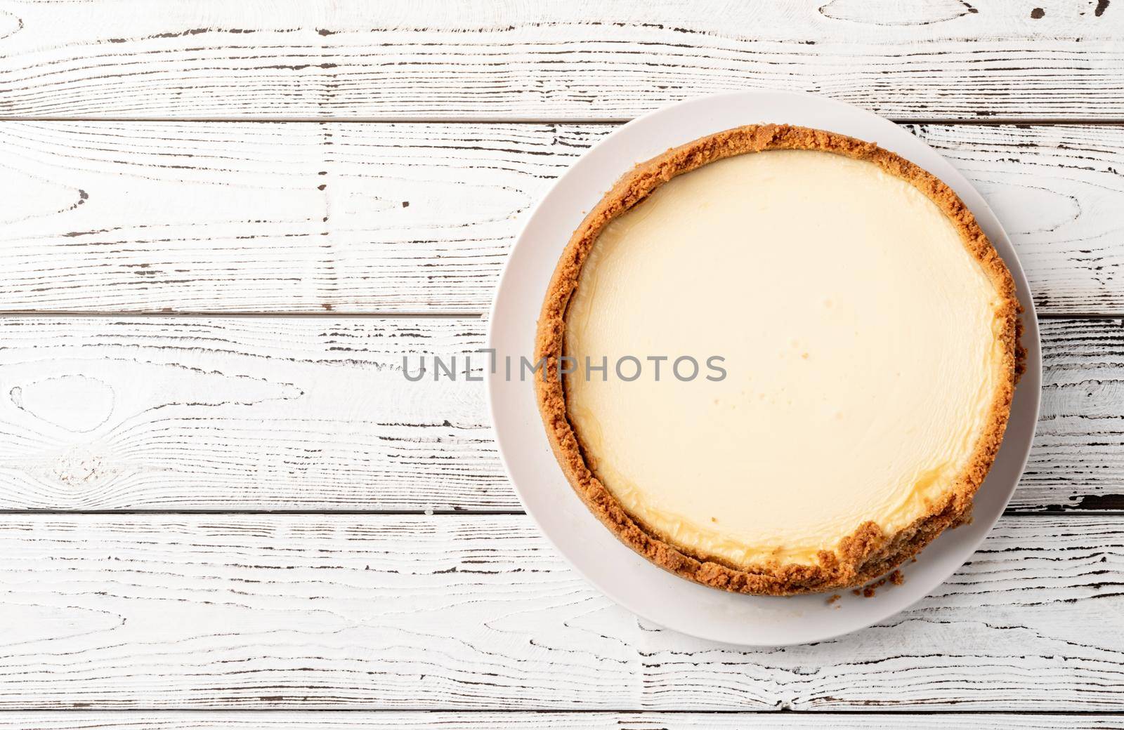Tasty homemade cheesecake on white wooden table with copy space