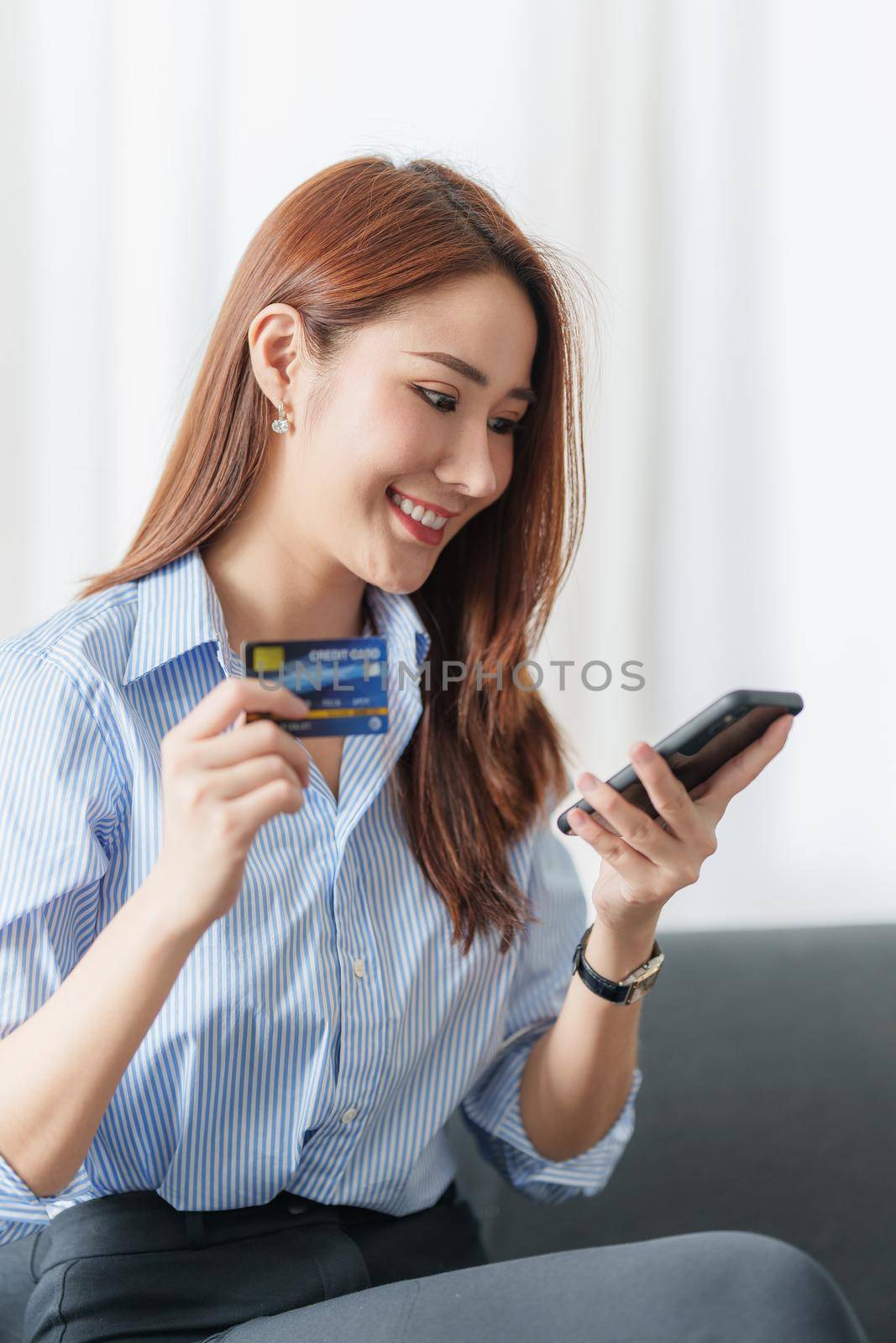 Woman using shopping application by cell phone and payment by credit card