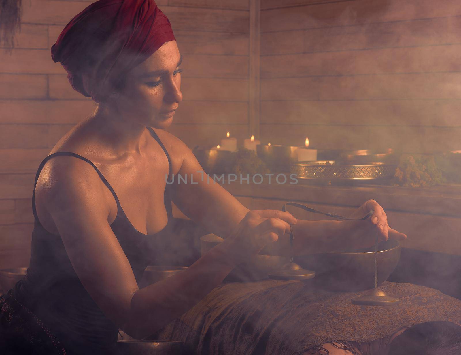 A woman performs a Tibetan ritual with sound bells. The concept of therapy.