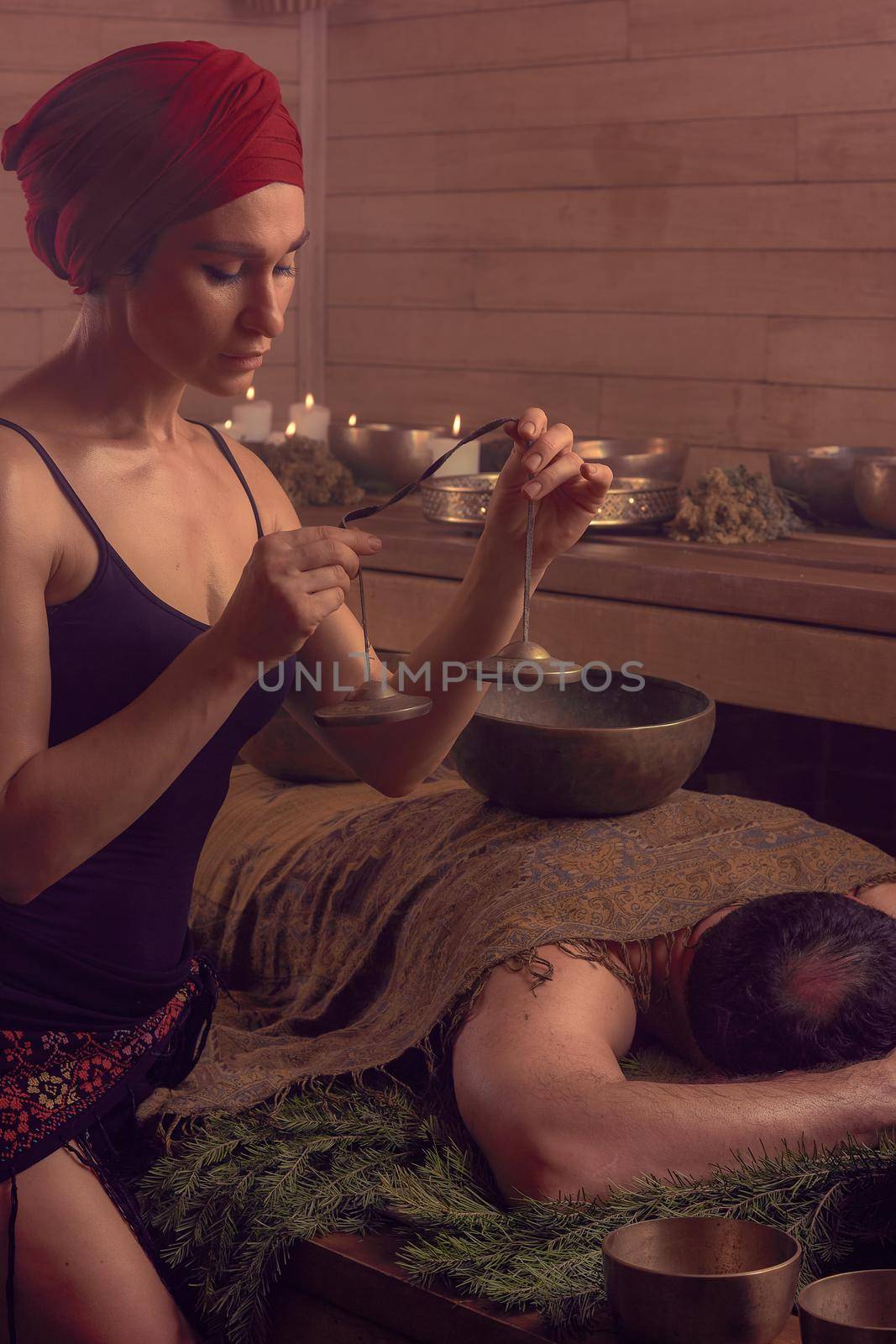 A woman performs a Tibetan ritual with sound bells. The concept of therapy by Yurich32